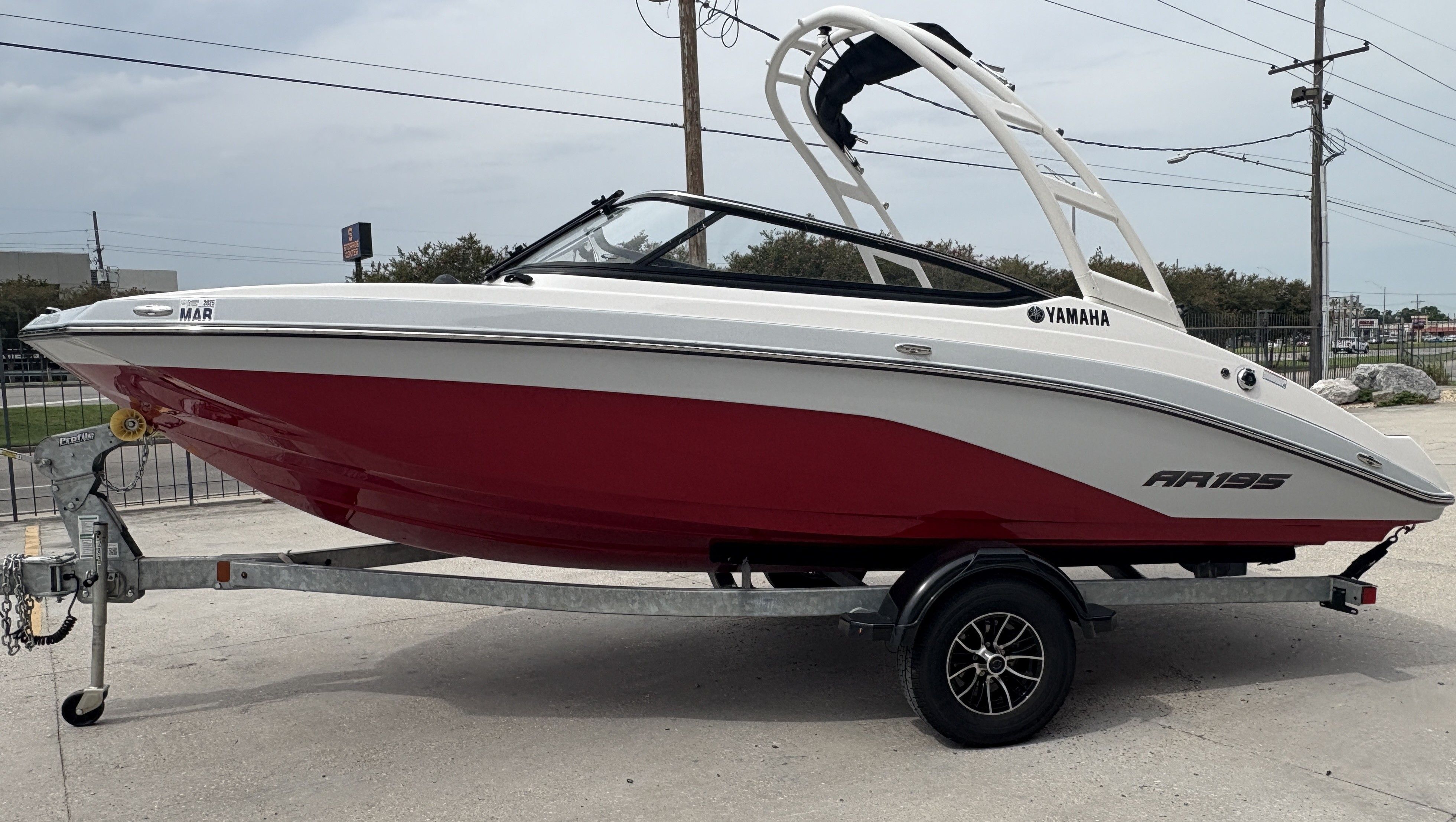 2024 Yamaha Boats AR 195 on trailer, red and white design, parked outdoors.