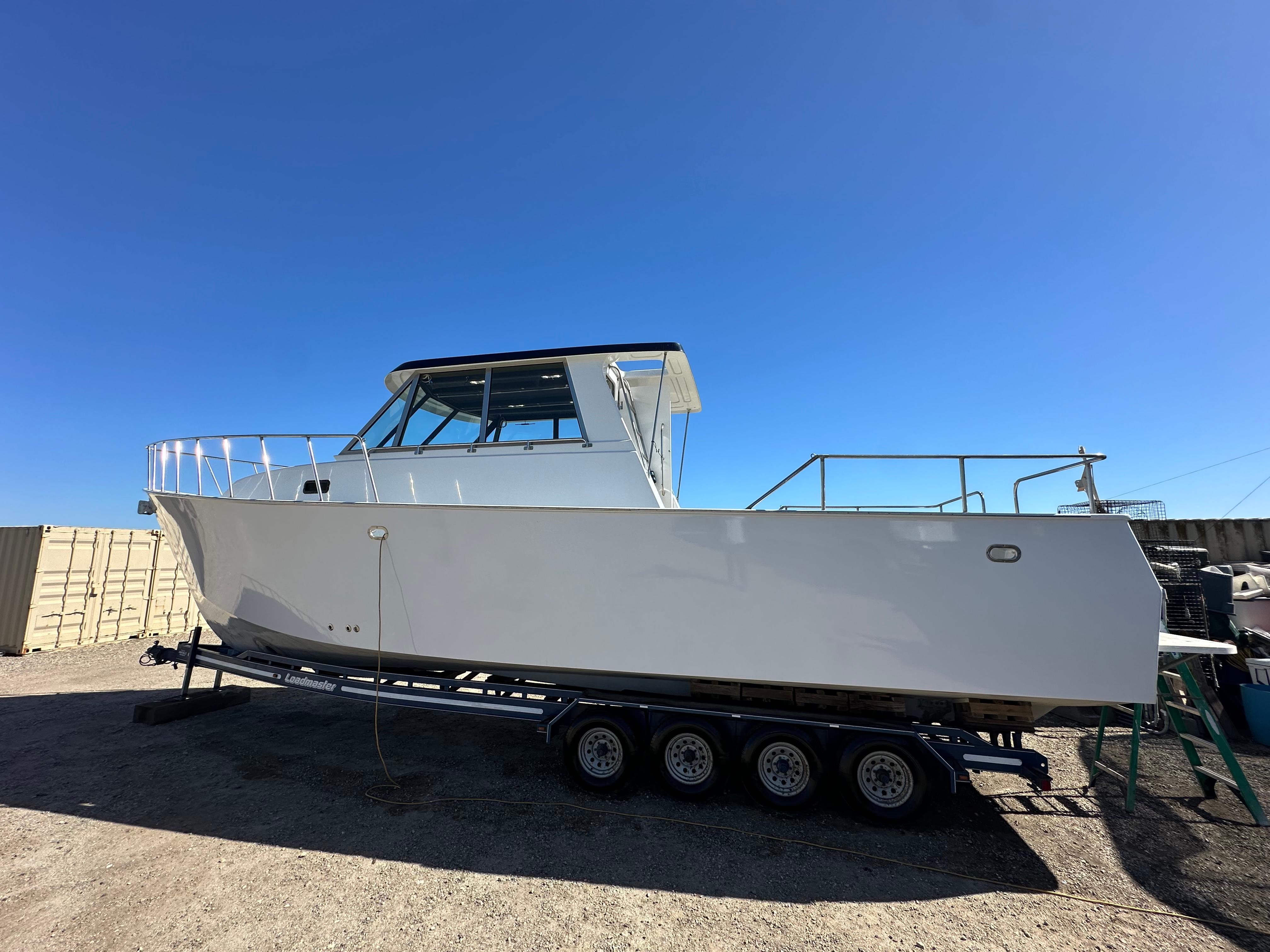 1992 Custom Hueneme Boat Works on trailer under clear blue sky.