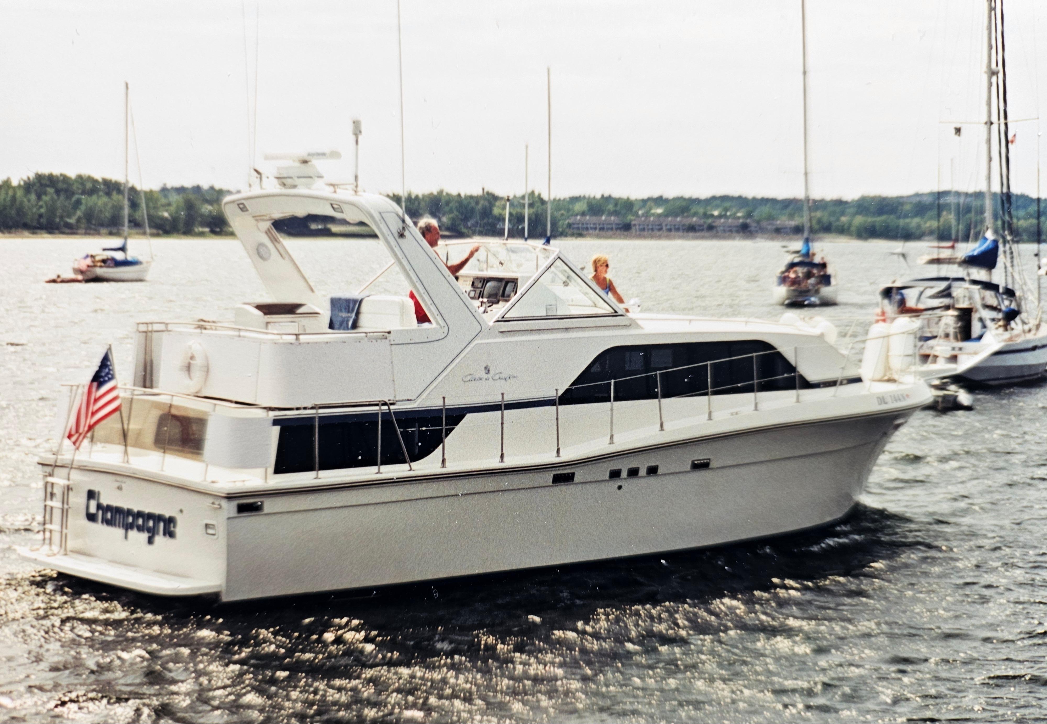1989 Chris-Craft Catalina 381 yacht cruising on a scenic lake with other boats nearby.