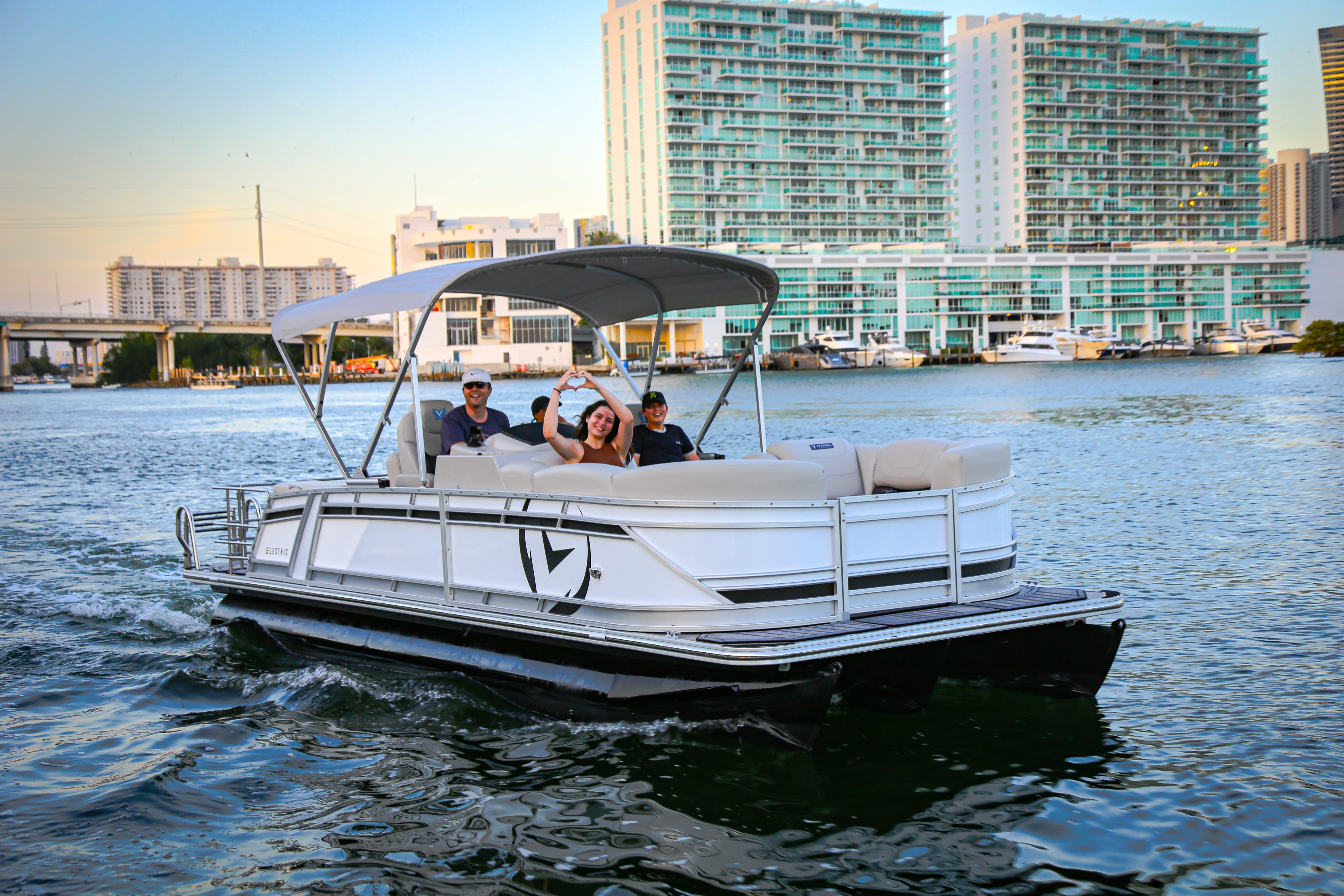 2025 Vision Marine Technologies V24 boat cruising with passengers on a sunny day.