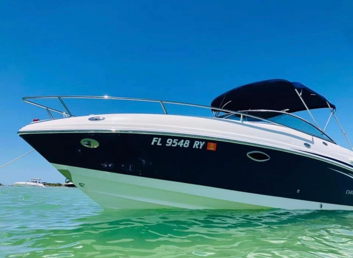 A 2007 Chaparral 235 SSi boat floats on clear water under a blue sky.