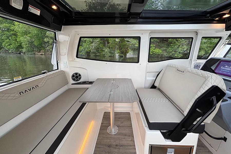 Interior of 2026 Navan C30 boat with seating, table, and large windows.