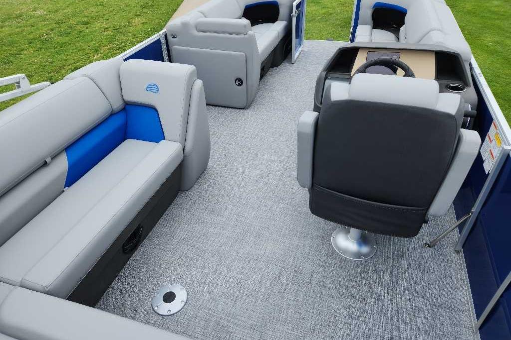 2026 Sun Tracker Party Barge 20 DLX interior with gray and blue seating, steering console.