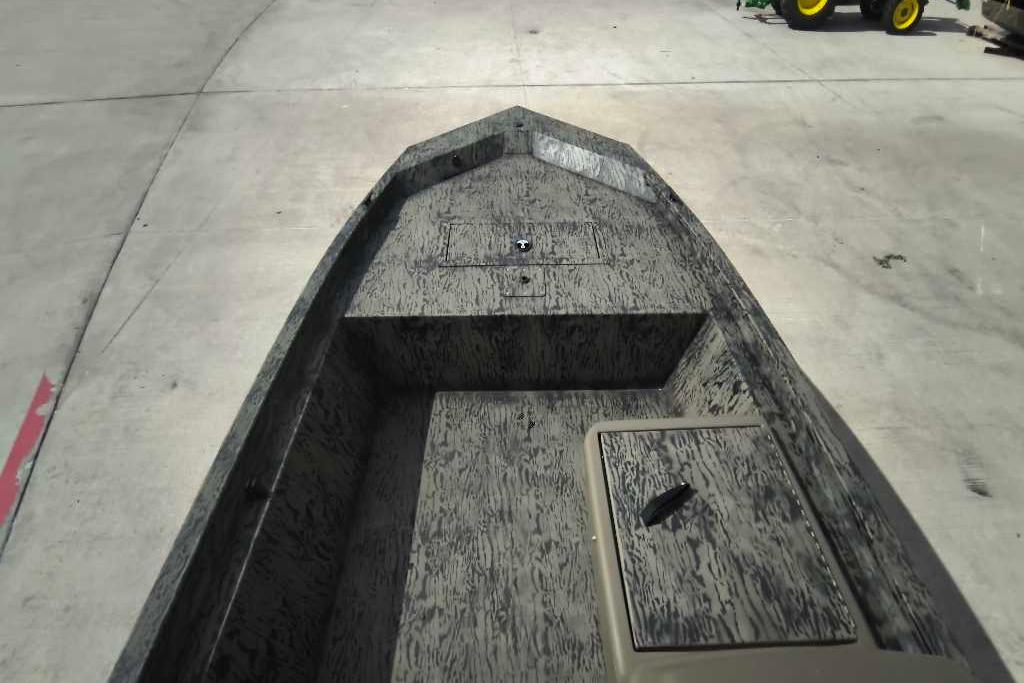 2026 Tracker Grizzly 1648 SC boat interior with textured flooring, docked on concrete.