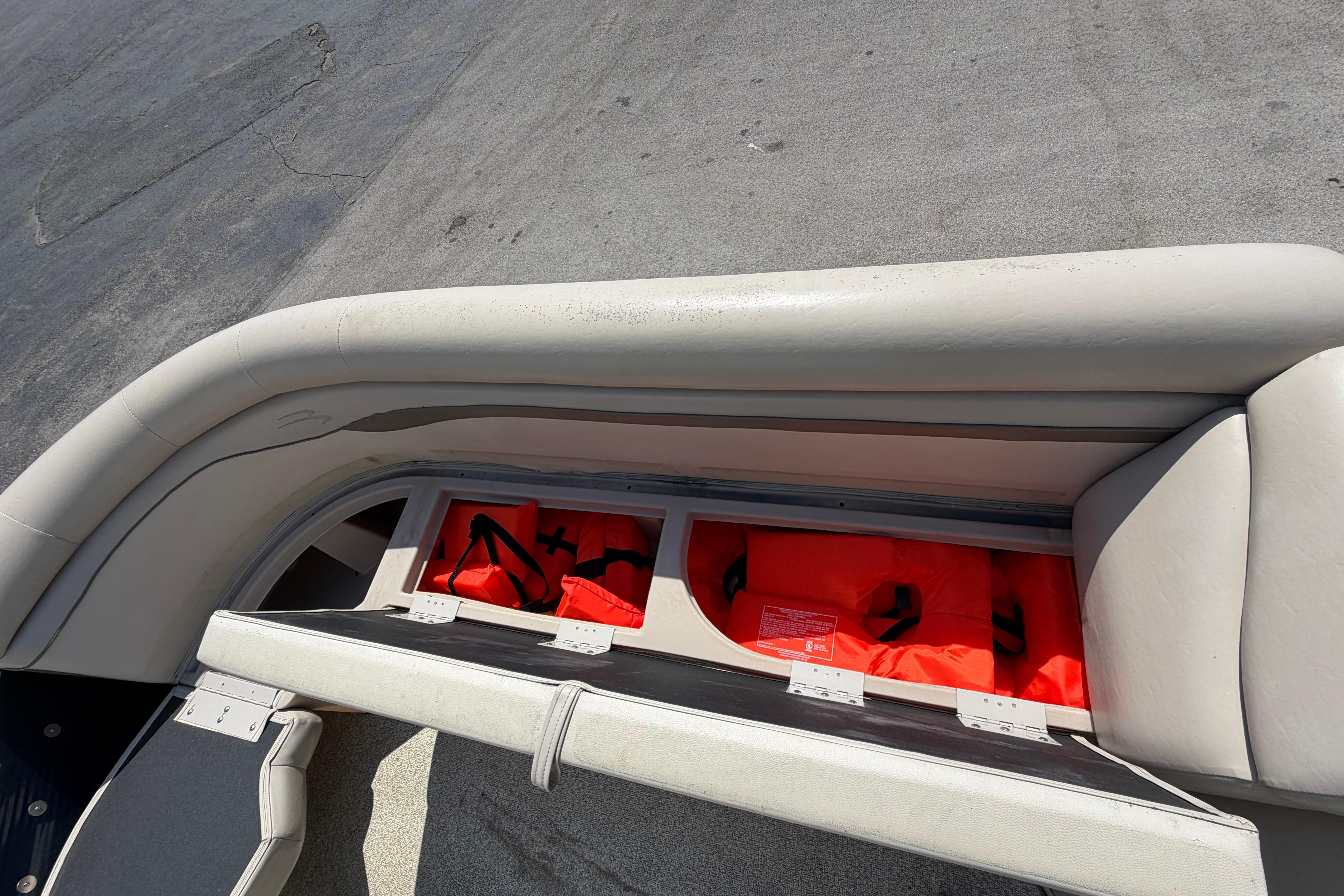 Storage compartment with life jackets on a 2017 Bennington 25 SSXAPG boat.