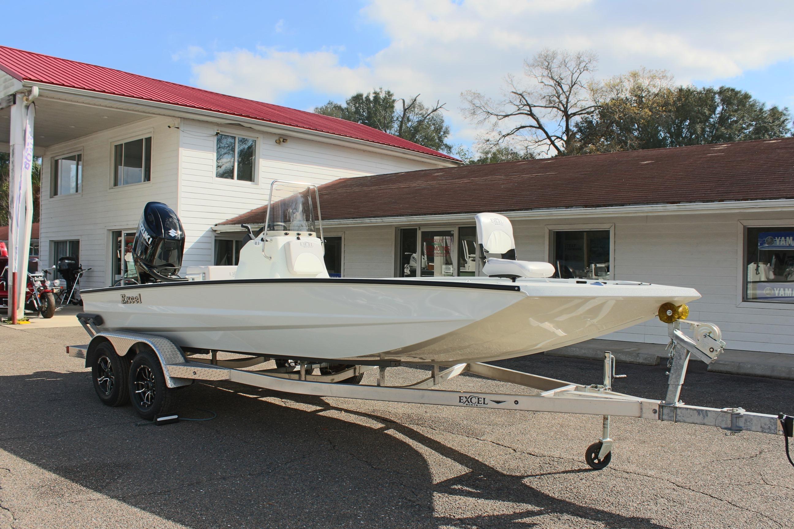 2025 Excel 2172 Stalker CC boat on trailer, parked outside a building.