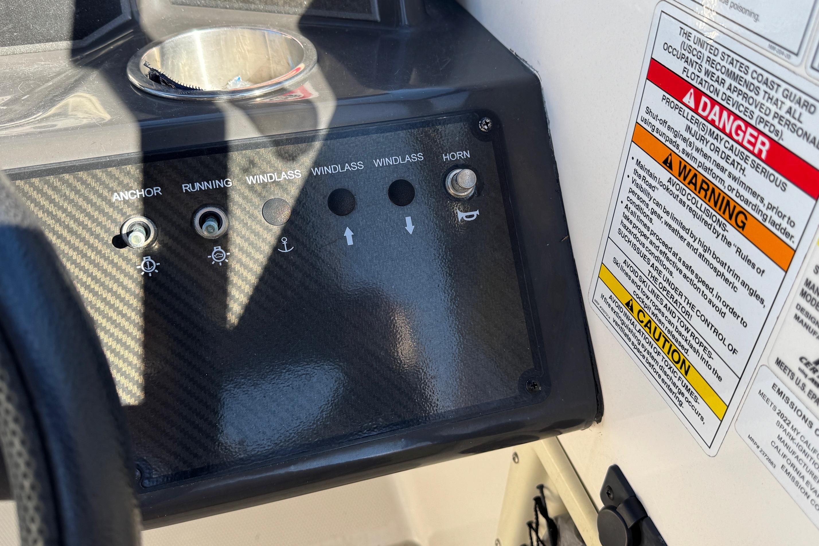 Control panel of 2022 Bayliner VR6 Bowrider OB with warning labels and switches.