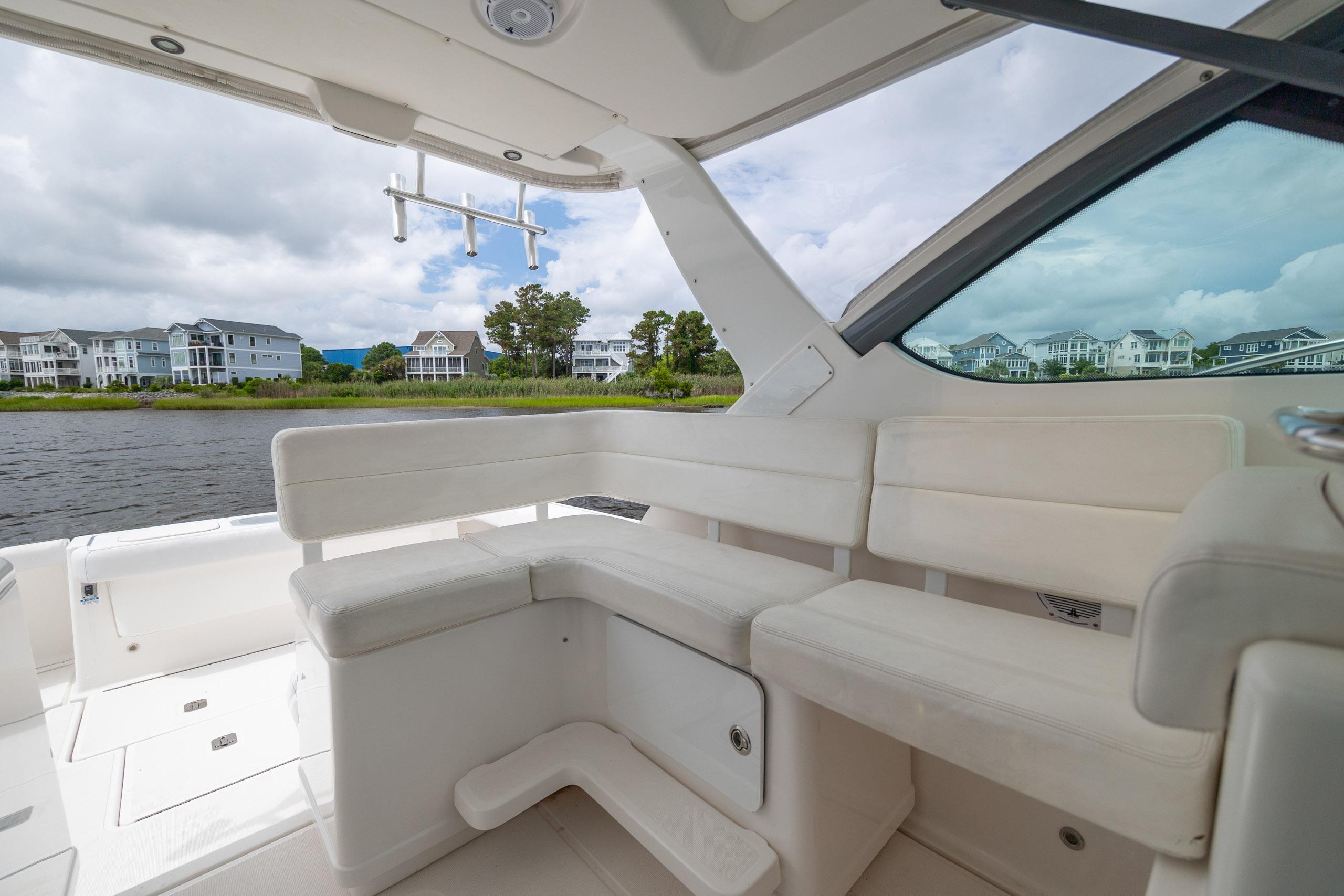 2004 Tiara Yachts 3200 Open interior with white seating, overlooking waterfront homes.