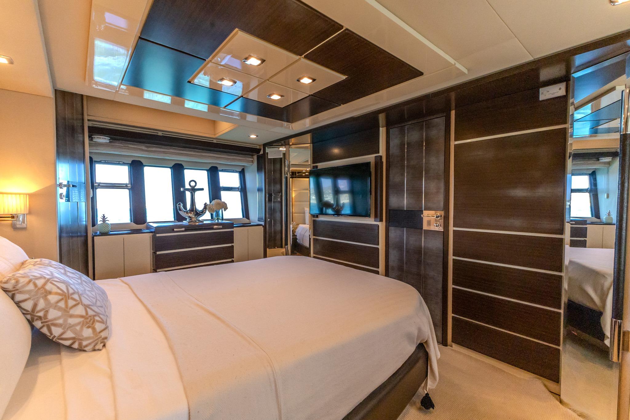 Luxurious bedroom interior of 2013 Azimut Fly 72 yacht with modern decor and large windows.