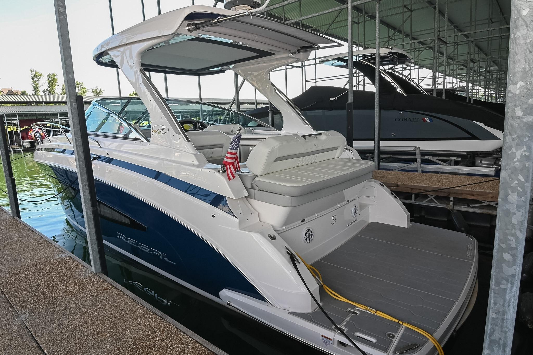 2021 Regal 33 Express boat docked in a marina, featuring sleek design and American flag.