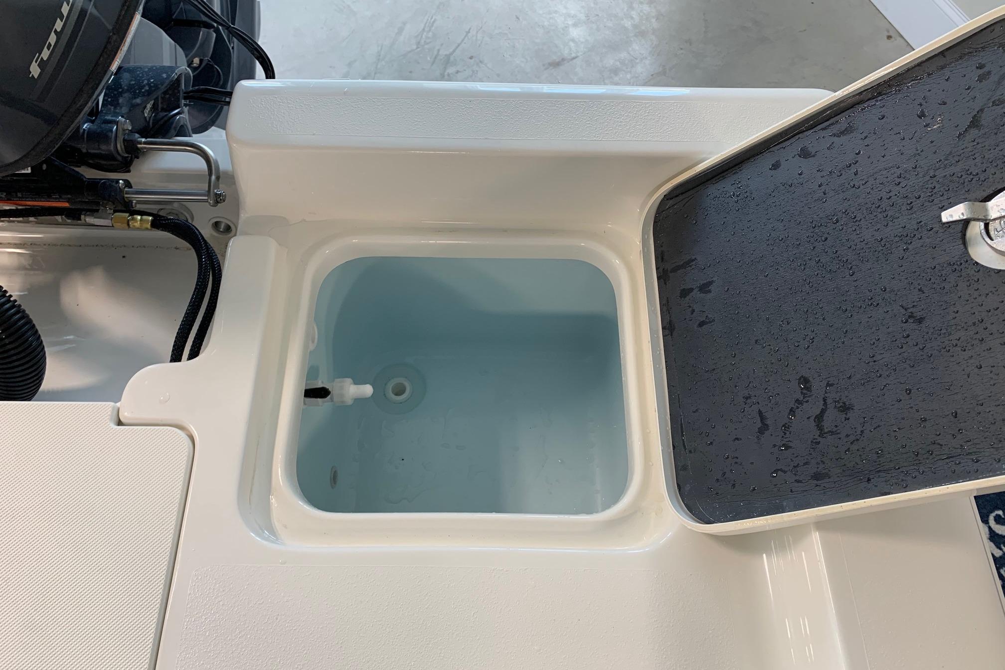 Livewell compartment on 2026 Key West 188 Bay Reef boat, open lid, showing interior.