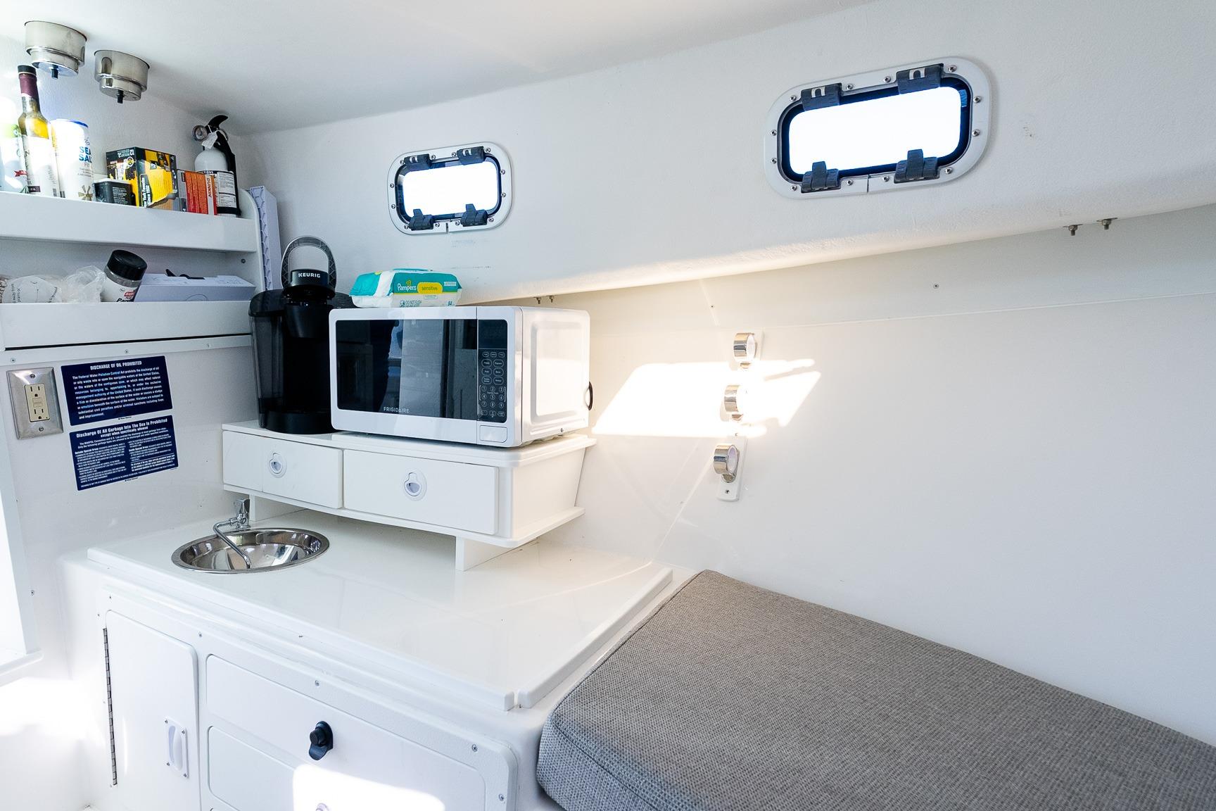 2024 Steiger Craft 31 Fisherman interior with kitchenette, microwave, and seating area.