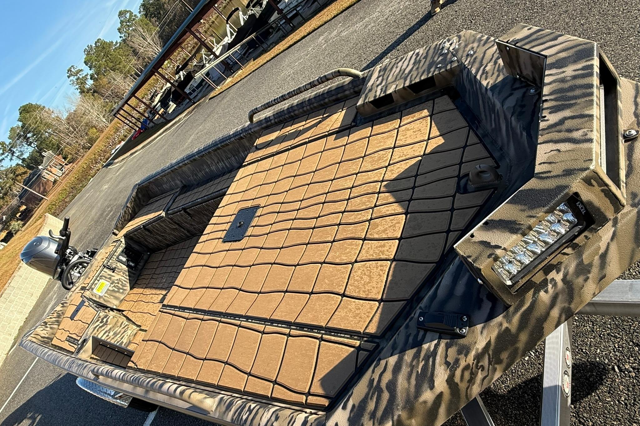 2026 Excel 1751 Shallow Water F4 boat with camouflage design on a trailer.