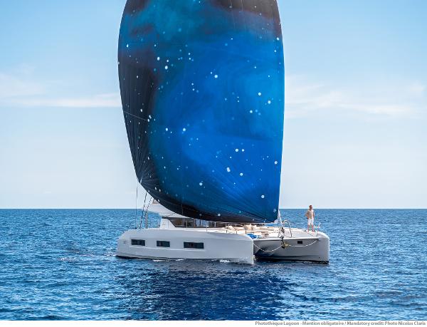 Sailing Lagoon 55 catamaran with starry sail on open sea, 2025 model.