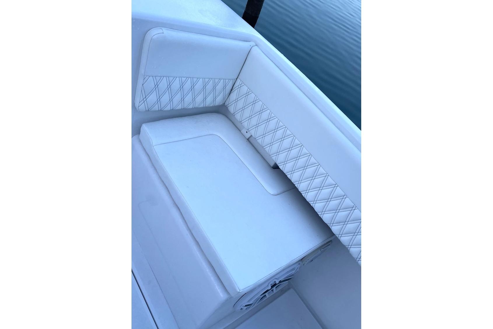 White cushioned seating on a 2002 Intrepid 323 Cuddy boat, featuring diamond-pattern stitching.