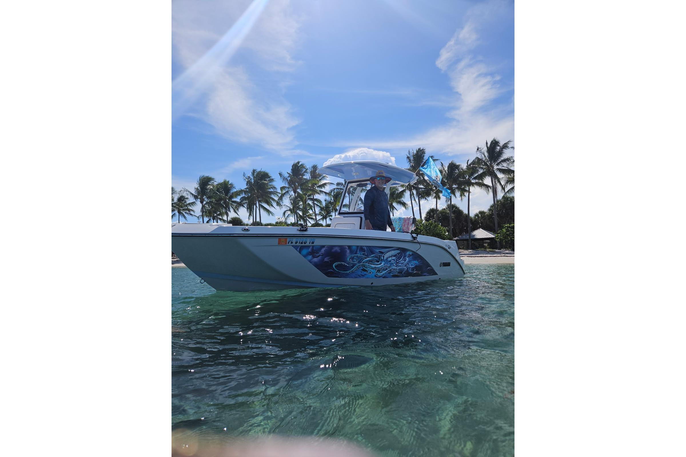 2024 Yamaha Boats 222 FSH Sport E on tropical water with palm trees in background.