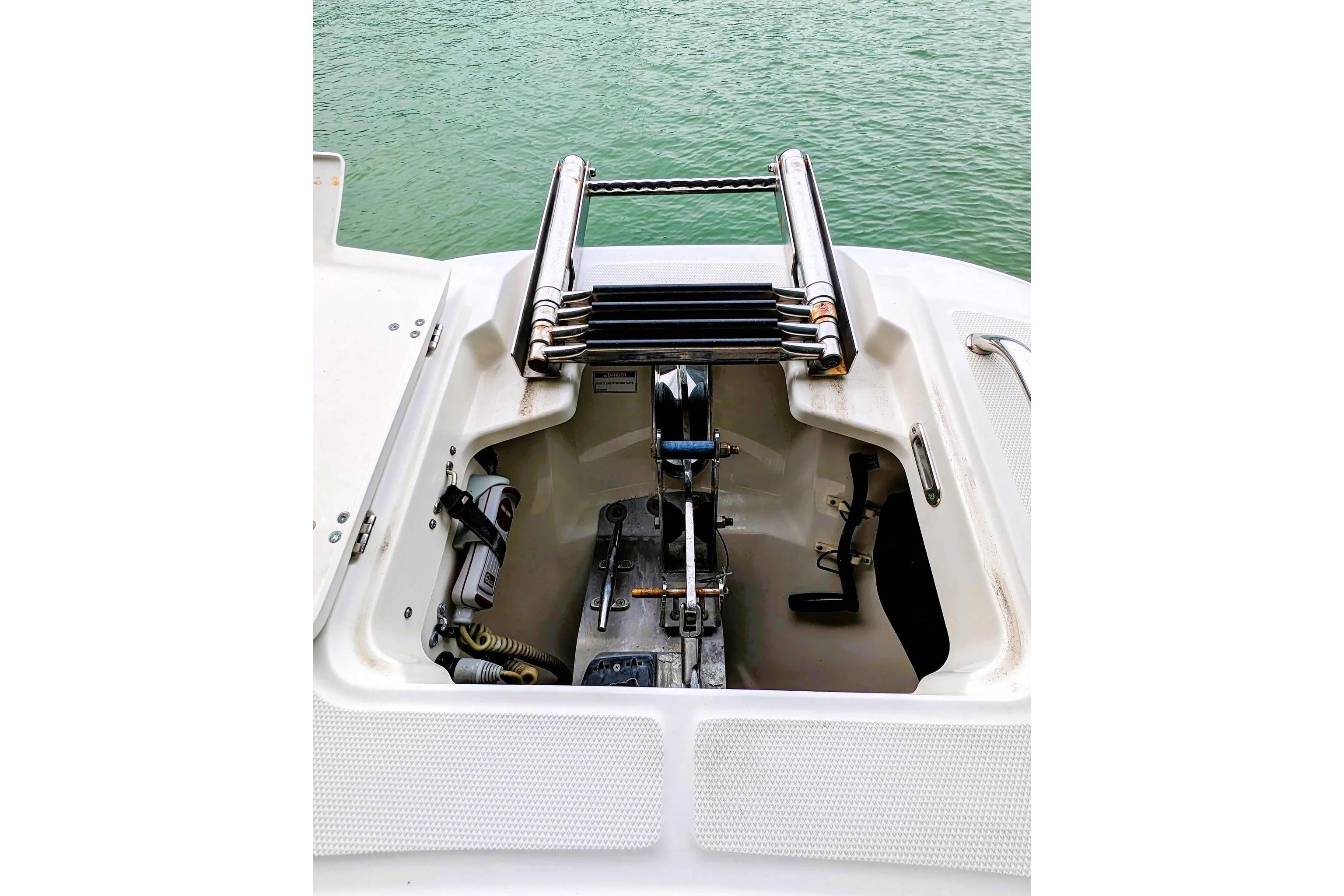 Boston Whaler 320 Vantage 2017 anchor compartment with ladder, docked on calm water.