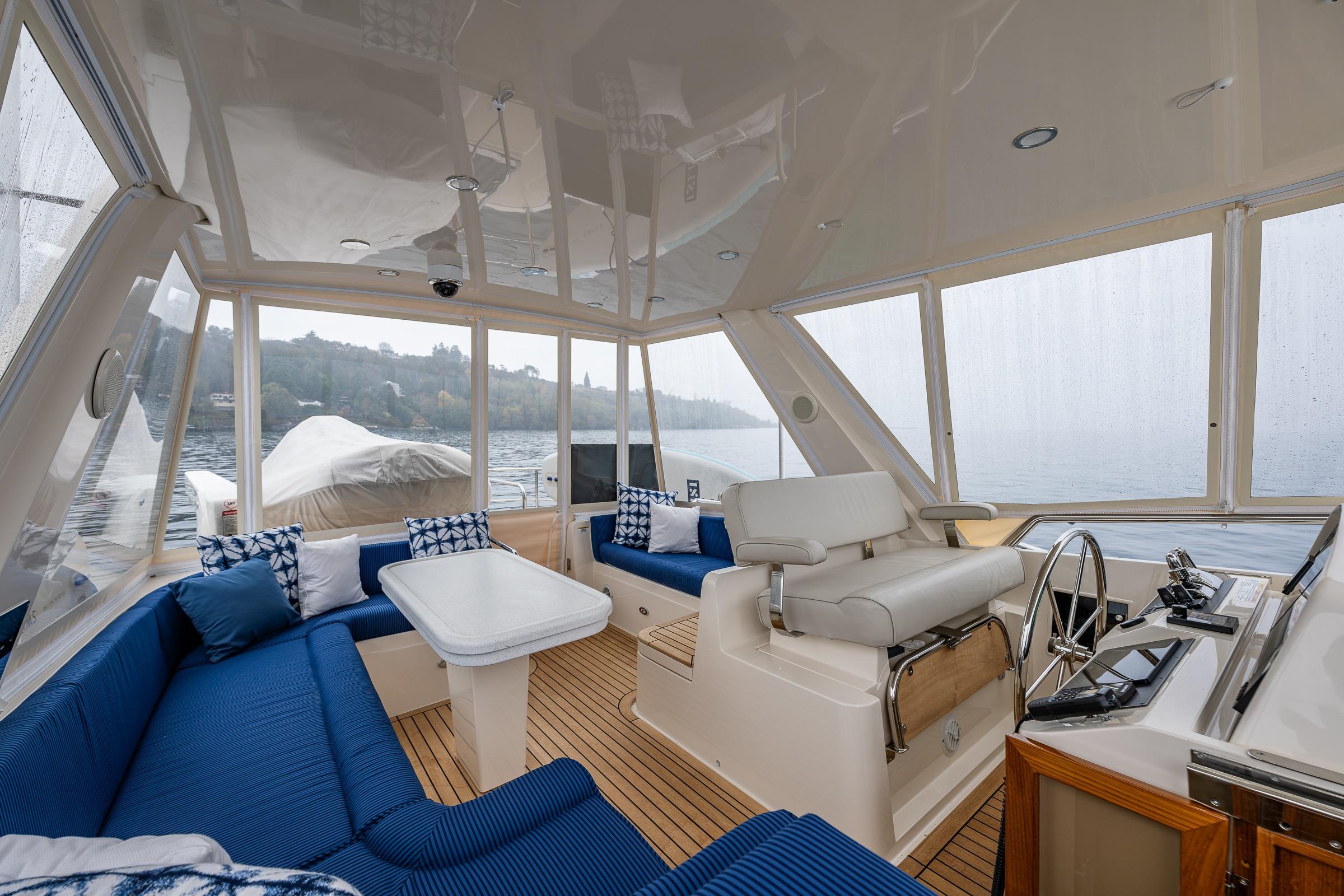 Luxurious 2026 Fleming 55 Pilothouse interior with blue seating and panoramic windows.