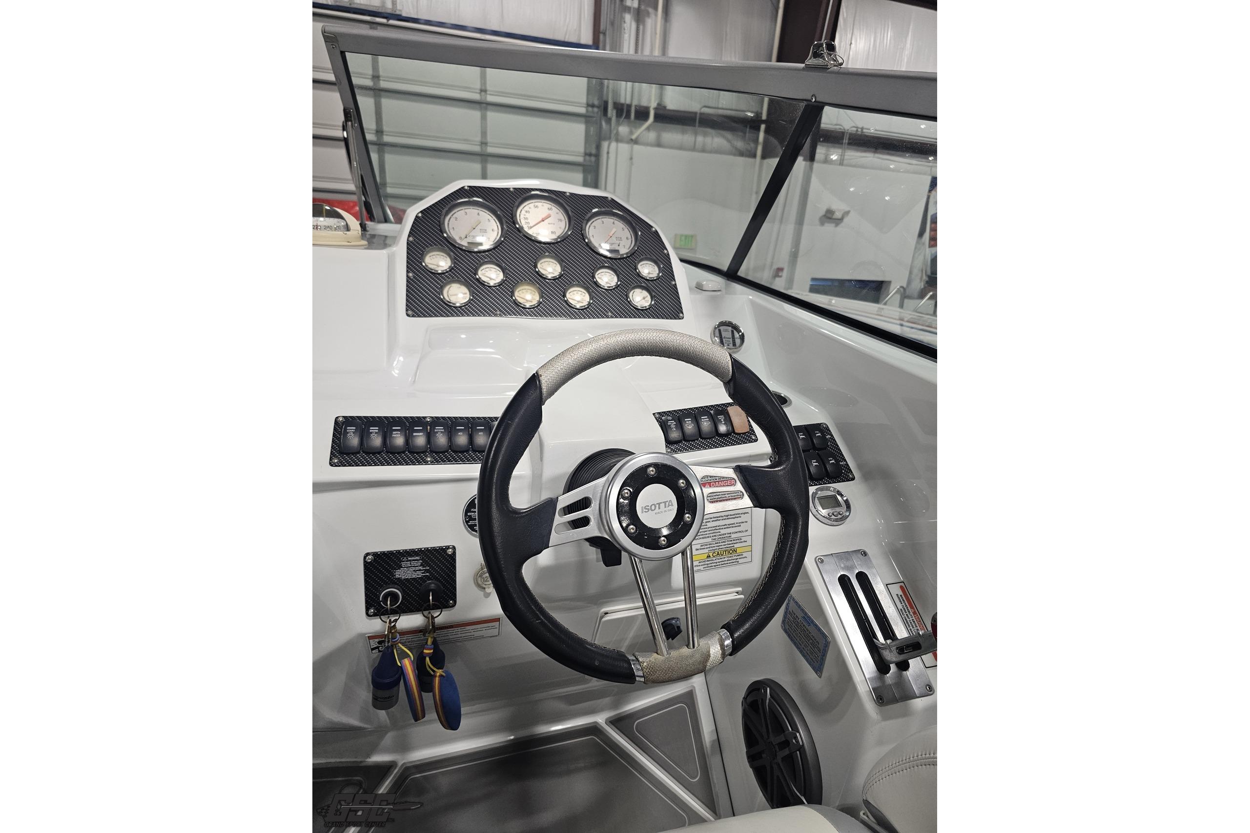 2008 Baja 335 Performance boat dashboard with steering wheel and gauges.