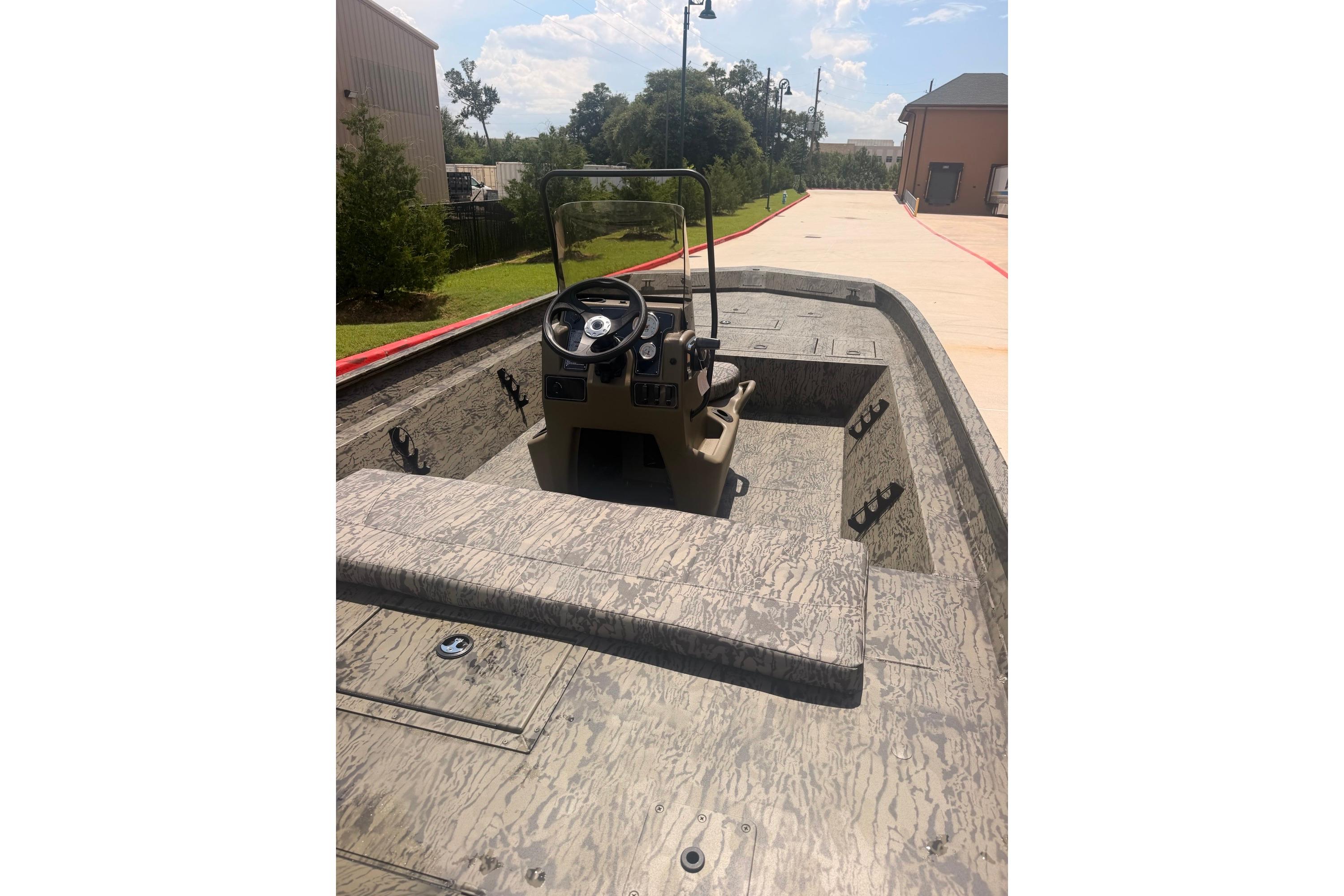 2026 Tracker Grizzly 2072 CC boat with center console, parked outdoors on a sunny day.