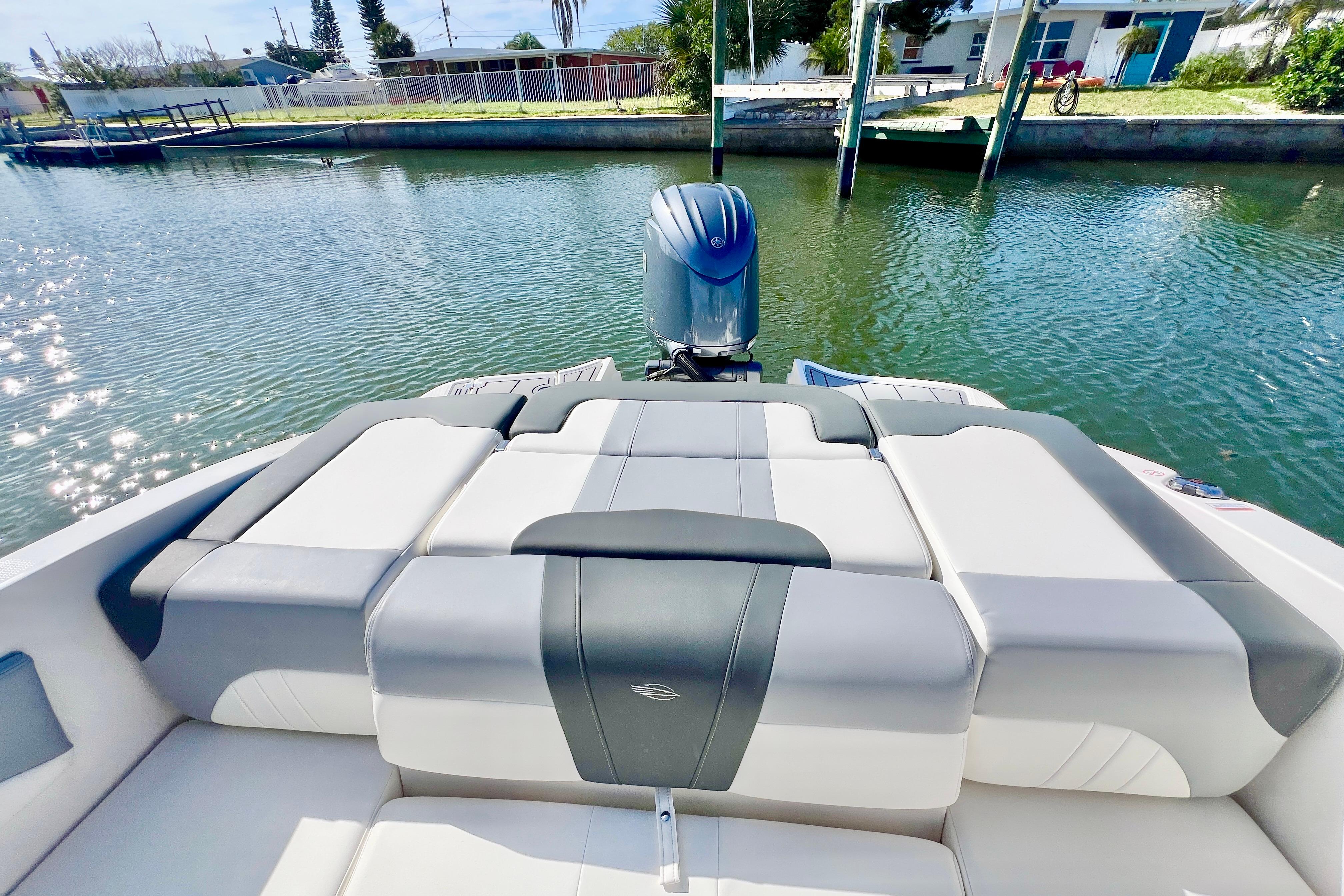 2023 Chaparral 21 SSi OB boat with sleek seating, docked by a serene waterfront.
