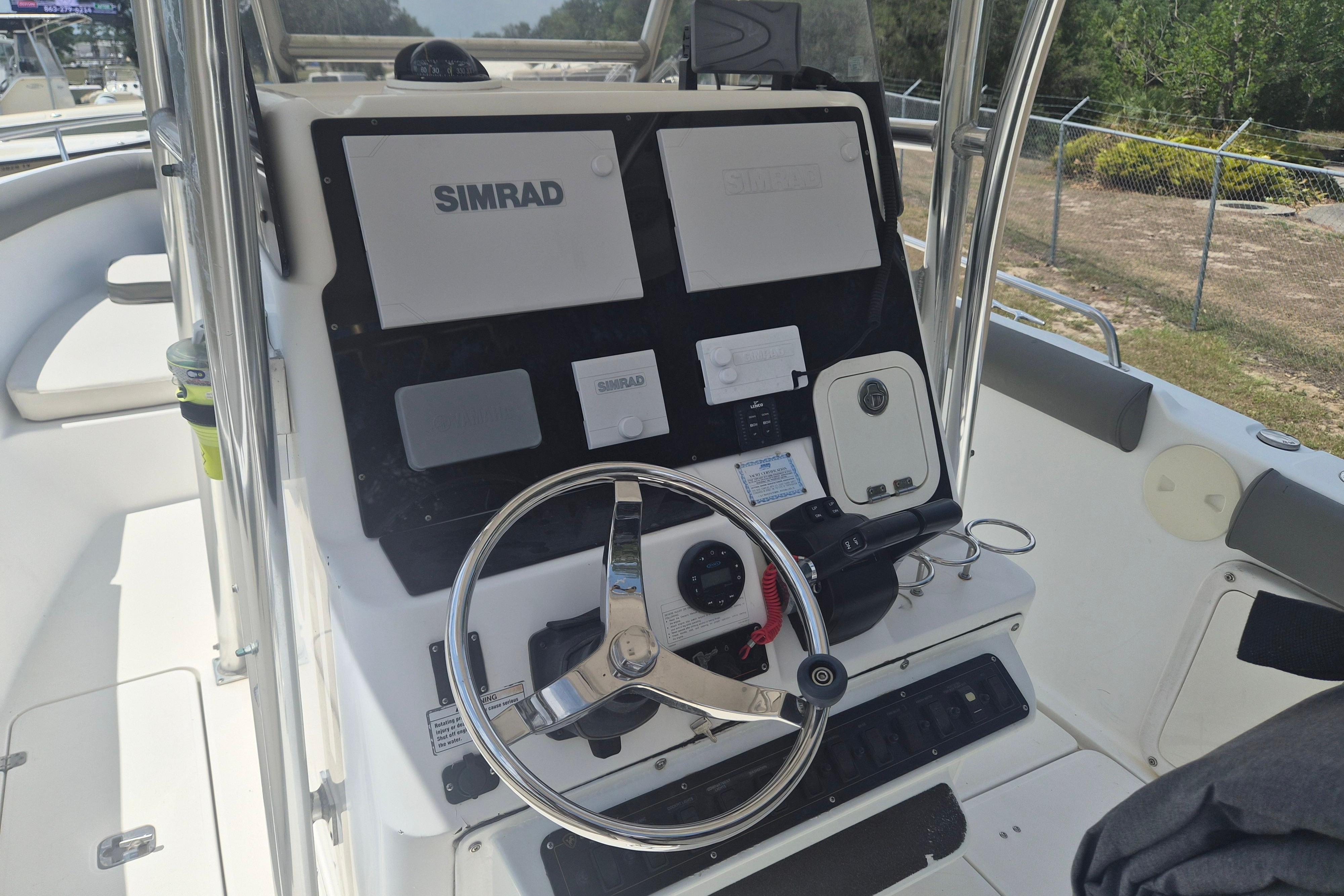 Century 2900 Center Console 2006 boat dashboard with Simrad navigation system and steering wheel.