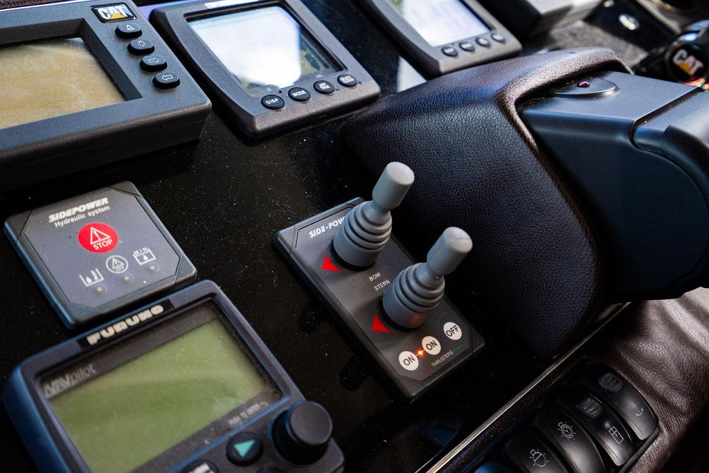 Control panel of a 2010 Princess V78 yacht with navigation instruments and joysticks.