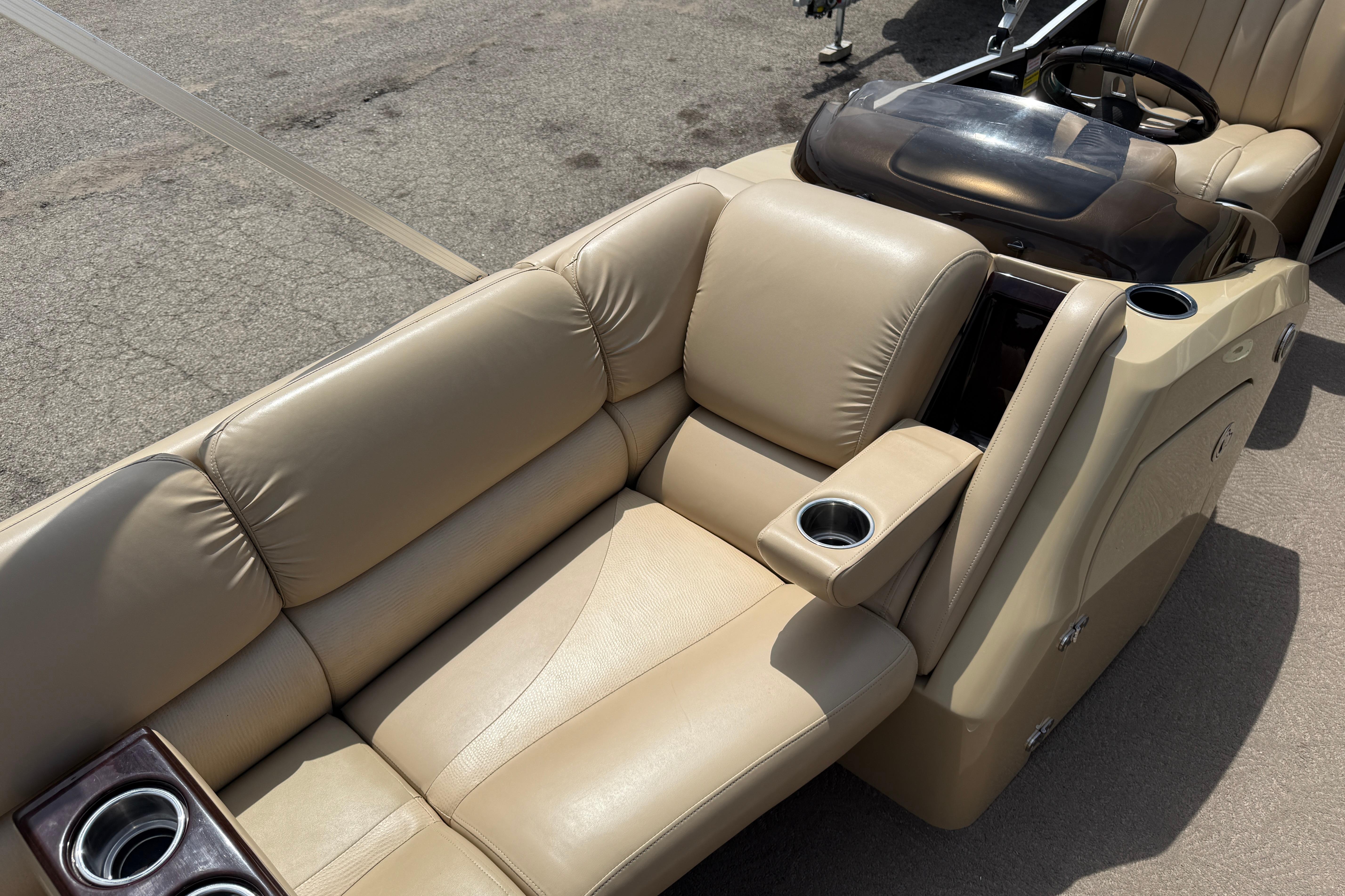 Luxurious beige seating on a 2011 Bennington 2575QCW I/O boat with cup holders.