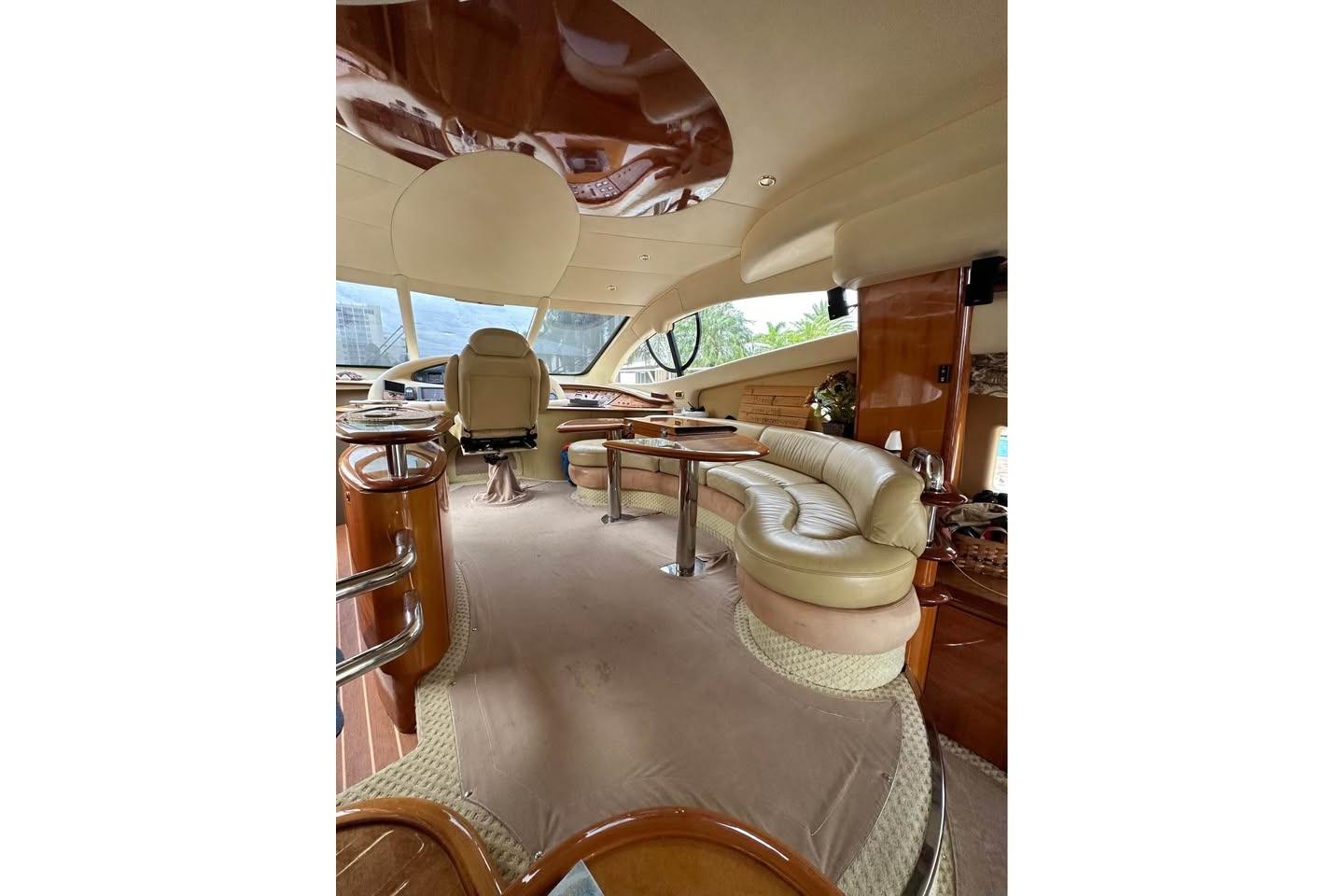 Luxurious interior of a 2004 Azimut 55E yacht with elegant seating and polished wood finishes.