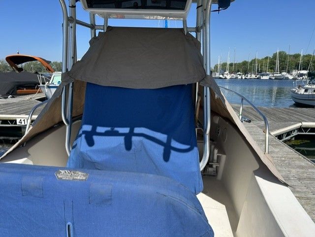A 2000 Aquasport Osprey 250 is docked. It features a blue cover.