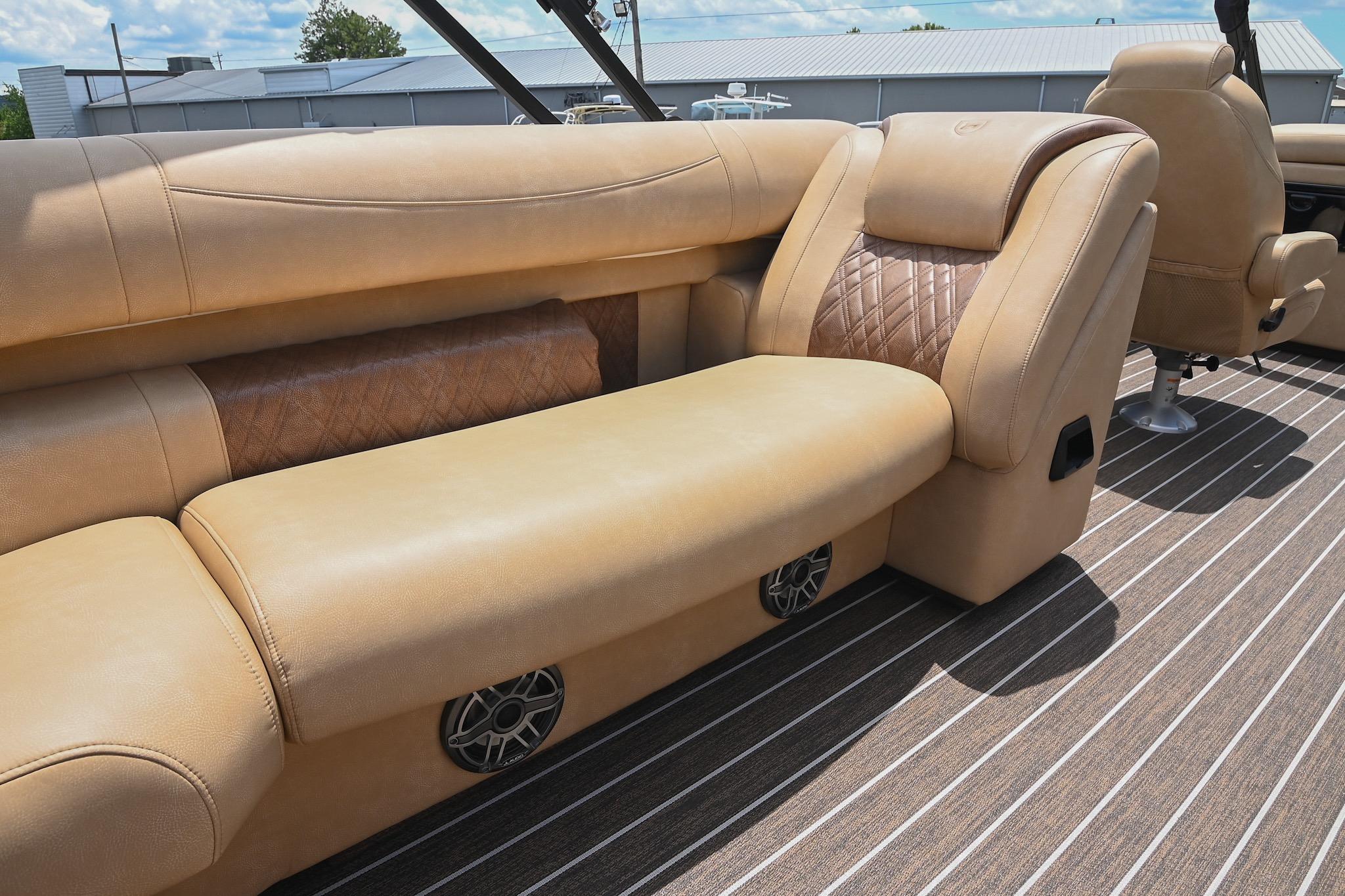 Luxurious seating on 2023 Premier 270 Intrigue RF boat with tan upholstery and striped flooring.