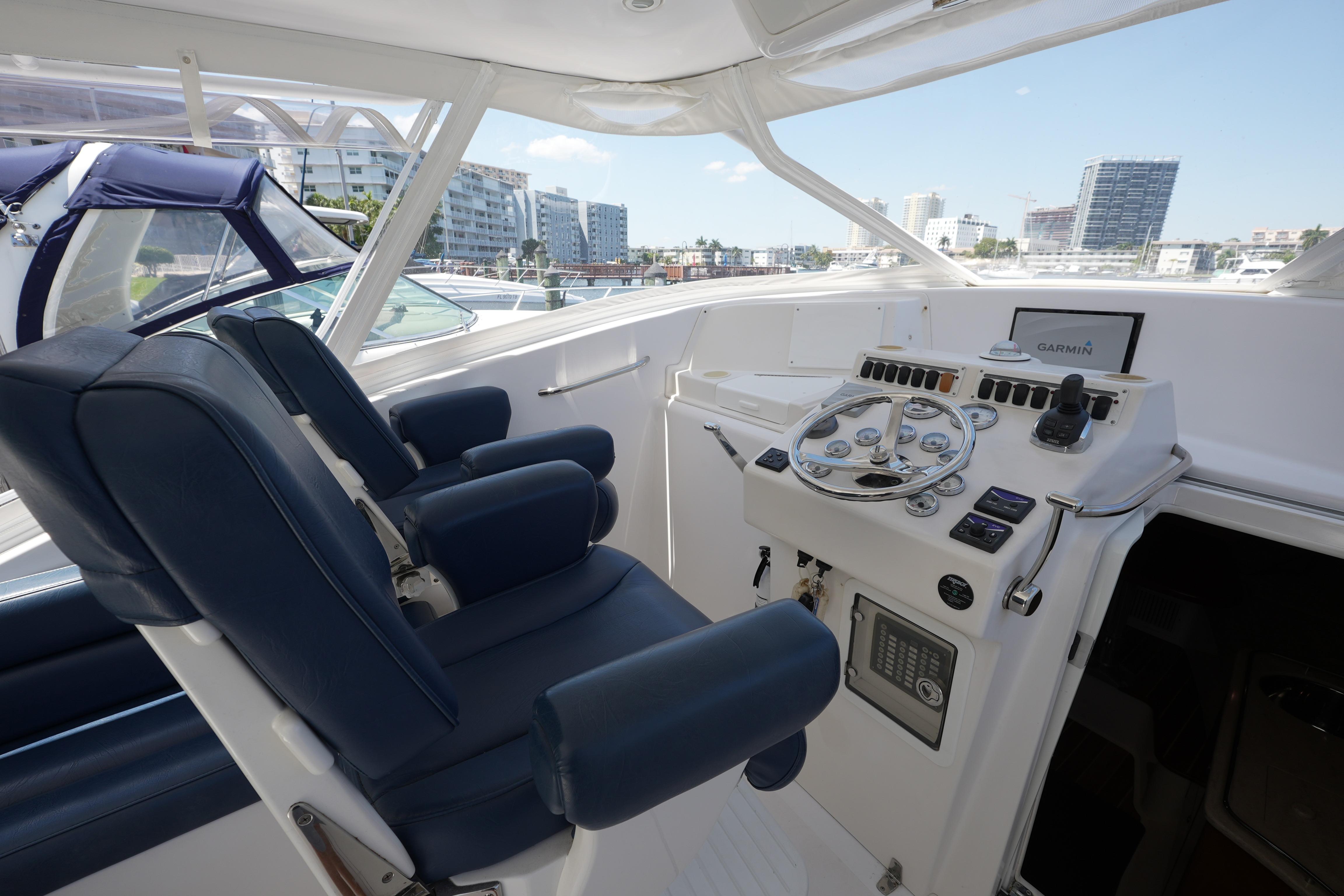 Interior view of 2012 Custom Carolina 34 yacht helm with blue seats and navigation controls.