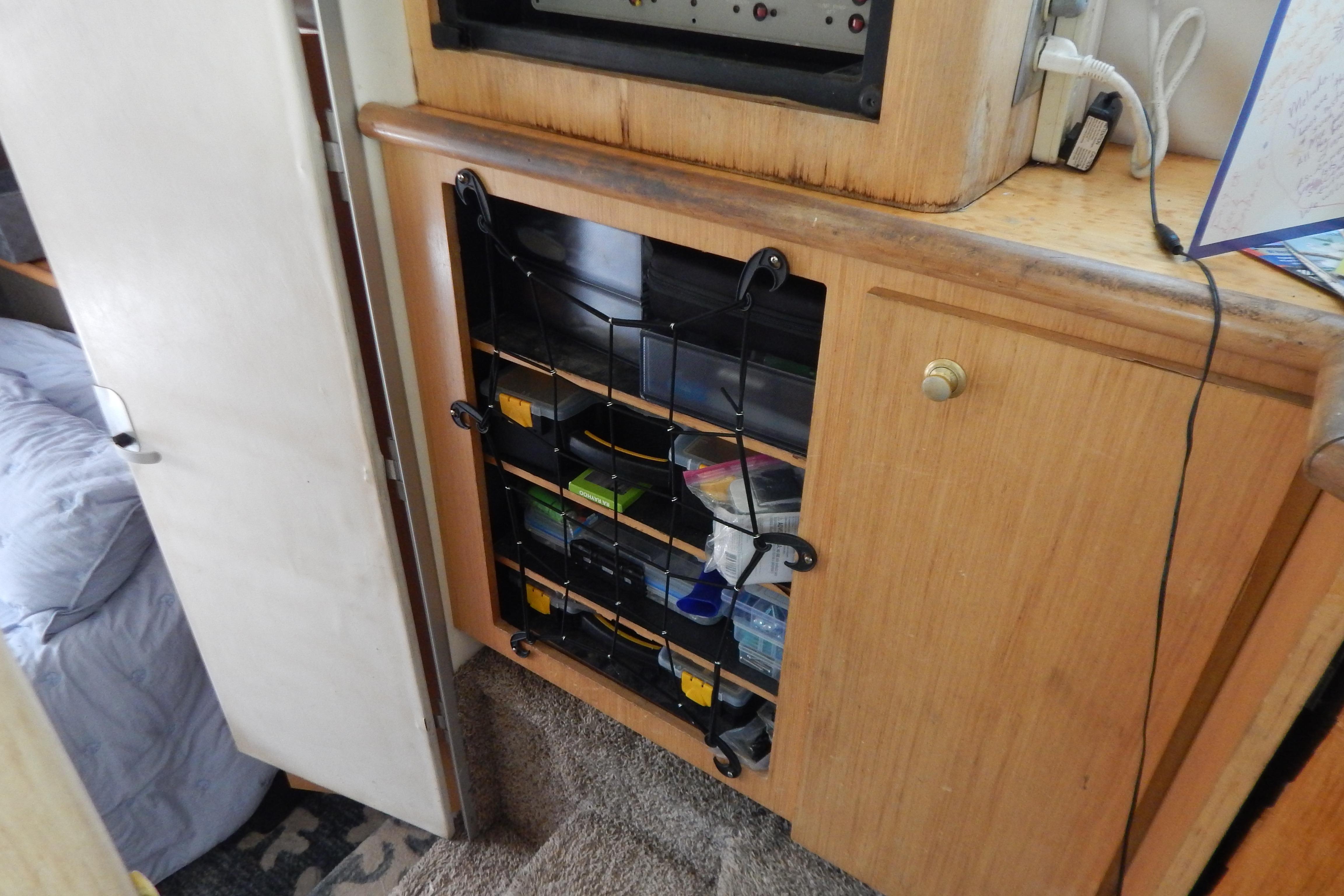 Wooden cabinet with storage shelves inside a 1998 Magnum 4100 SCR boat interior.
