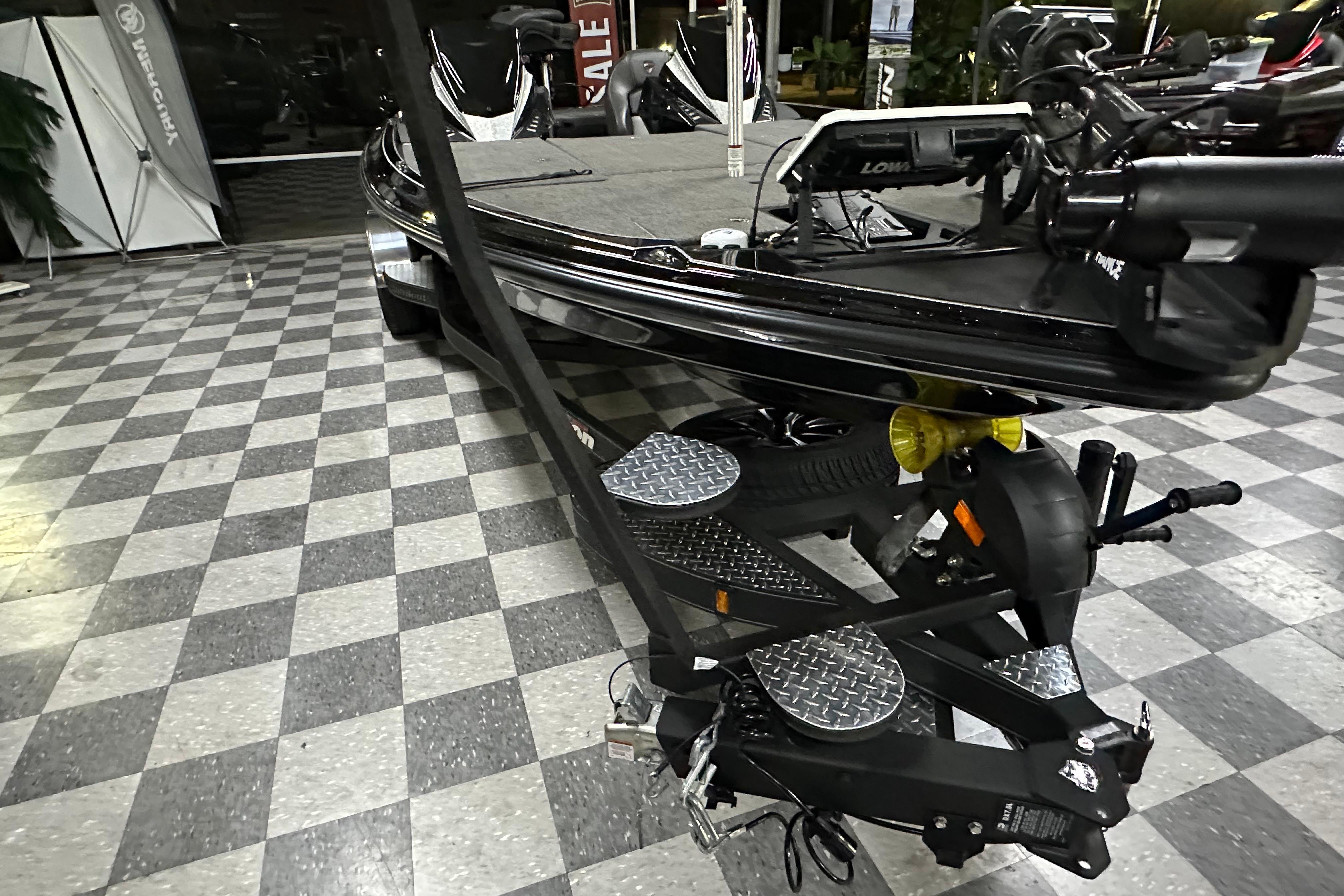 2025 Triton 21XP Patriot boat on checkered floor in showroom.
