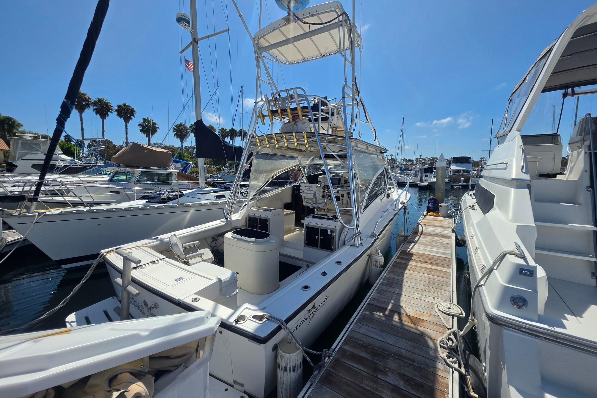 1999 Albemarle 305 Express Fisherman docked at marina under clear blue sky.