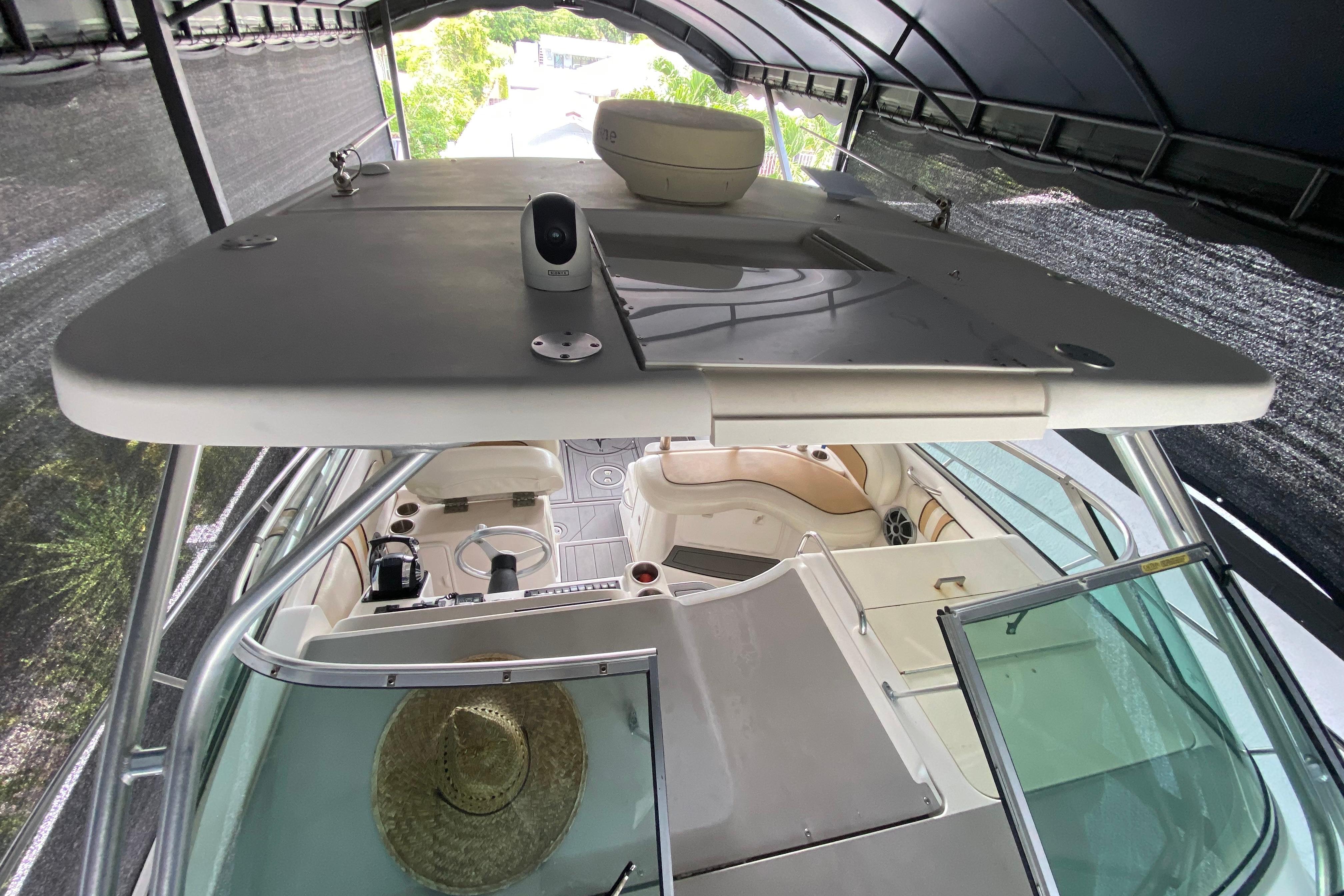 2005 Wellcraft 290 Coastal boat interior under canopy, featuring helm and seating area.