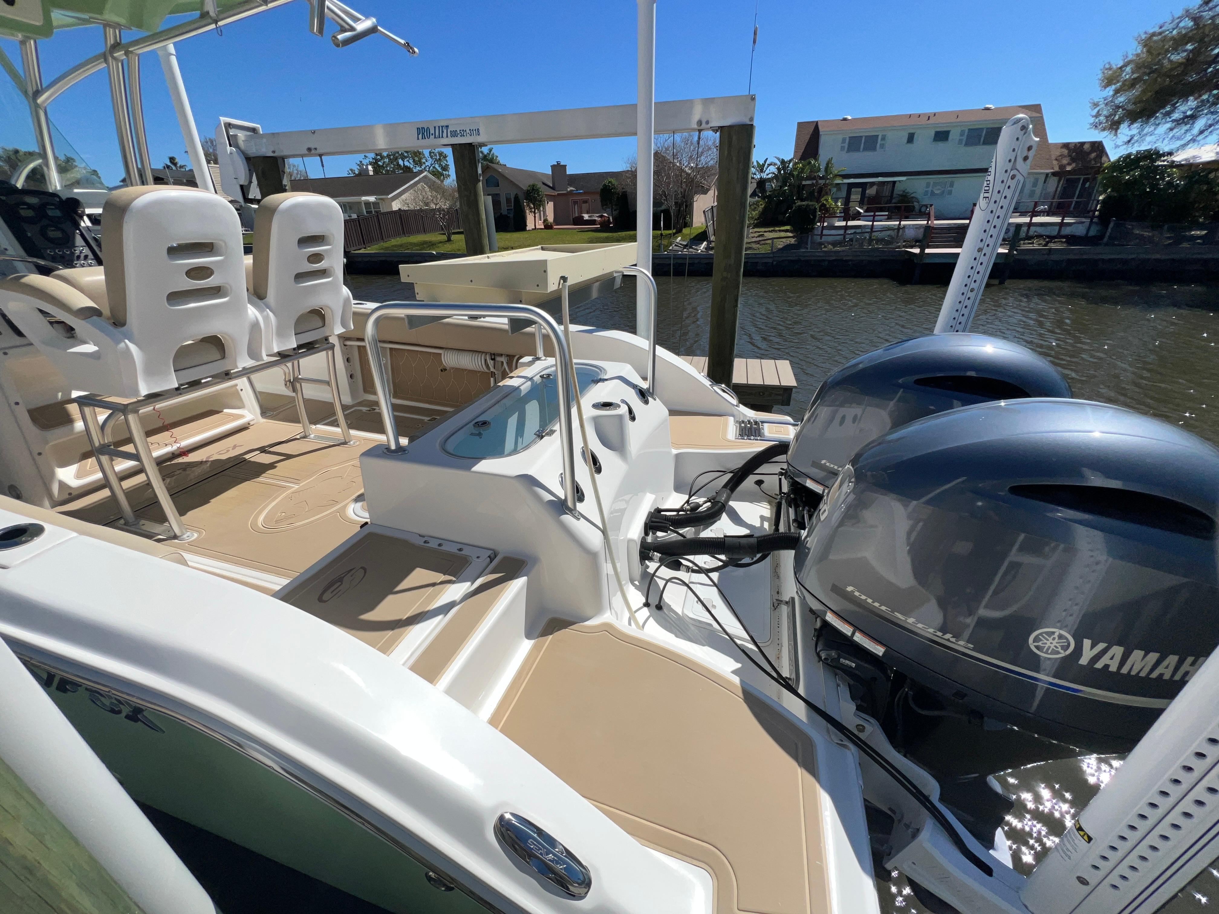 2016 Sea Fox 266 Commander boat with dual Yamaha engines docked by waterfront homes.