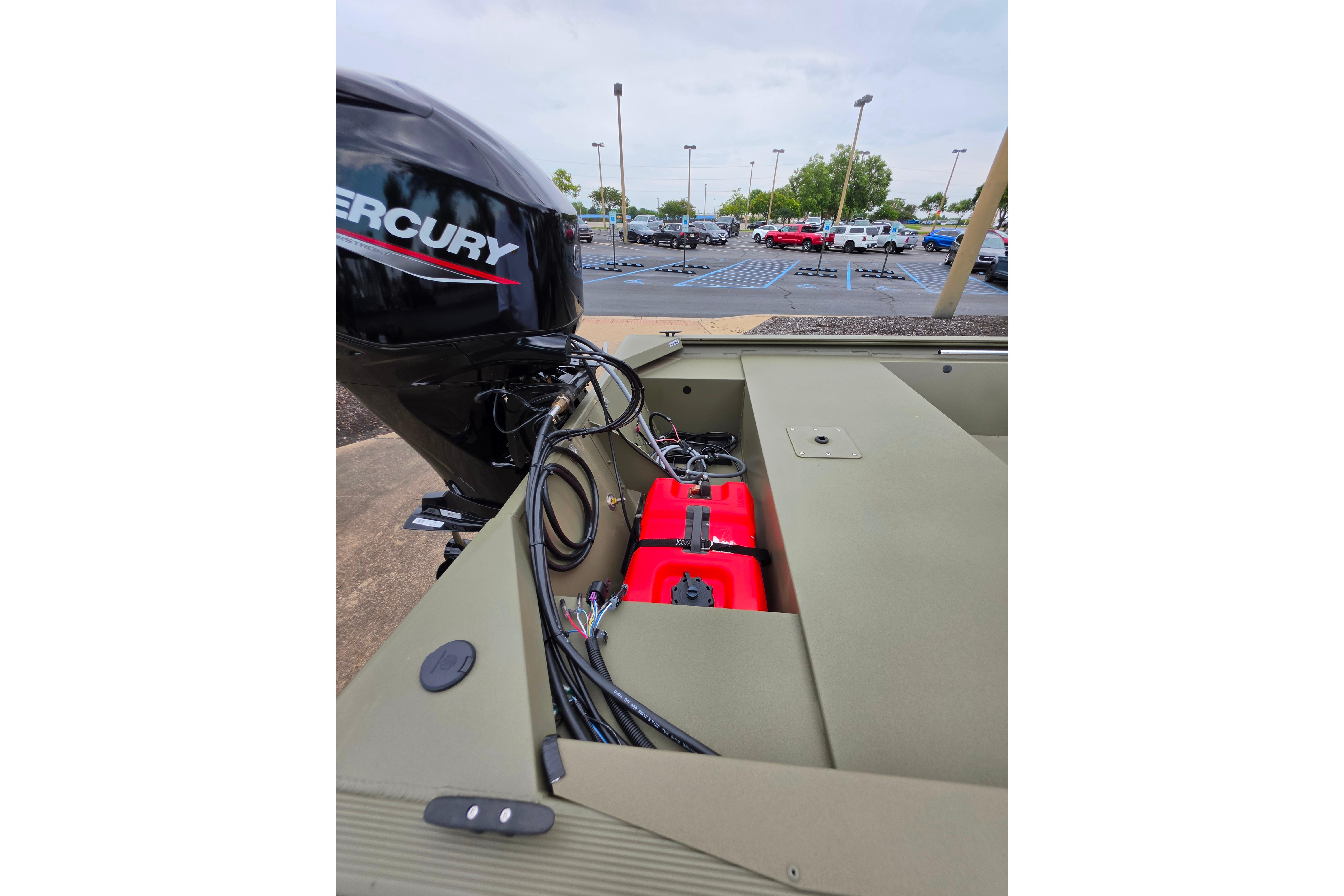 2026 Tracker Grizzly 1648 SC boat with Mercury engine in parking lot.