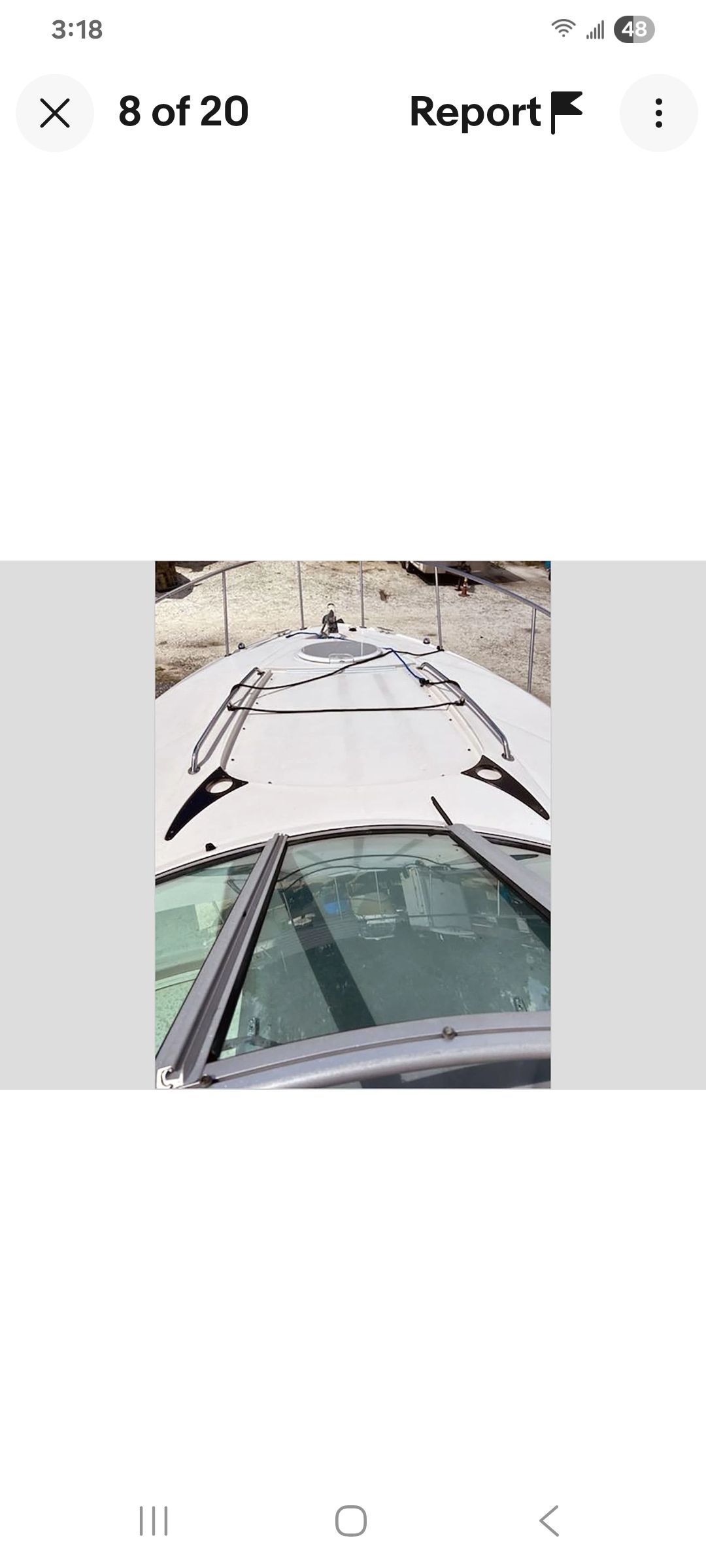 Top deck of a white boat with railing and glass windows.