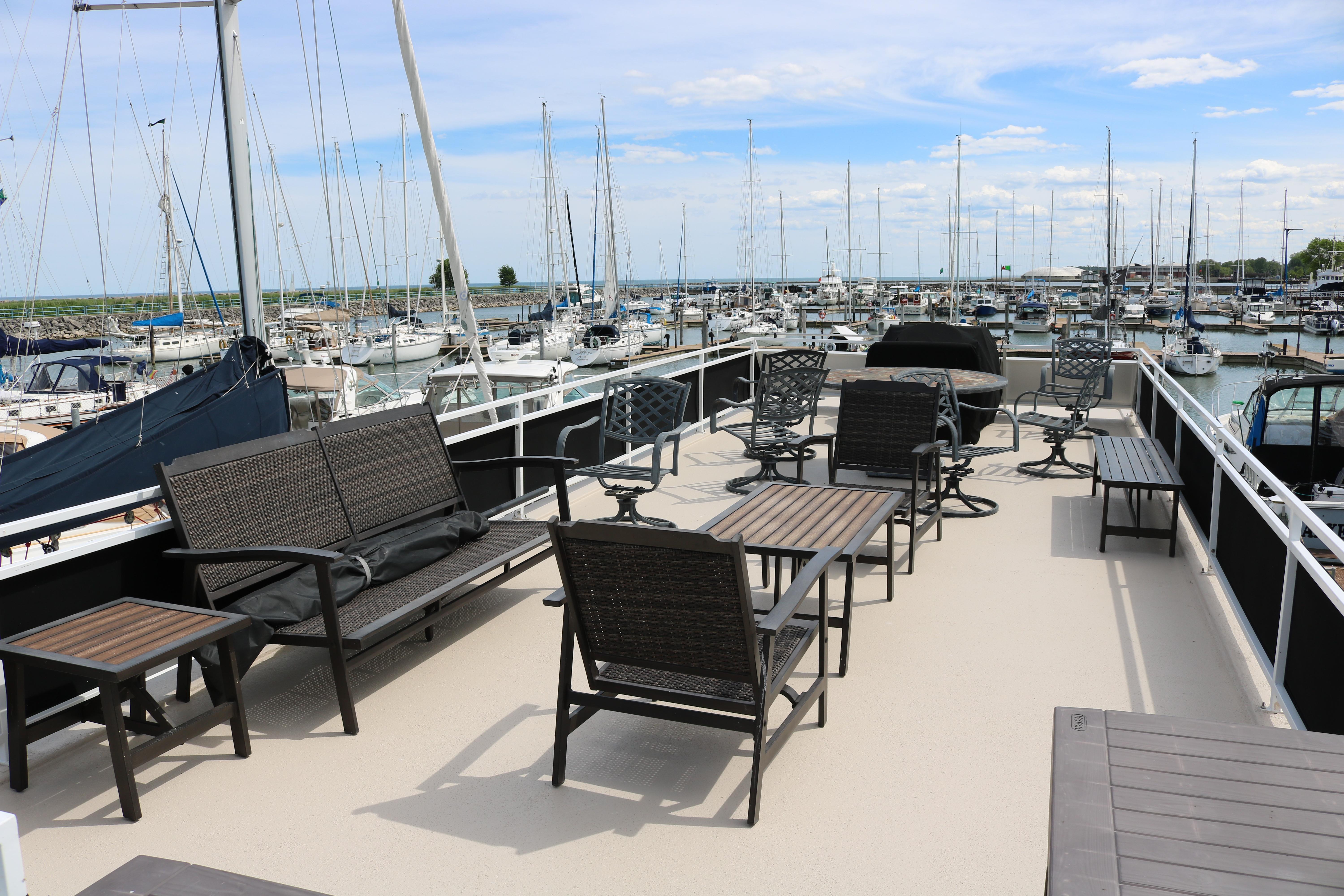 Spacious deck of 2010 Skipperliner 480 Flybridge with outdoor seating, overlooking marina.