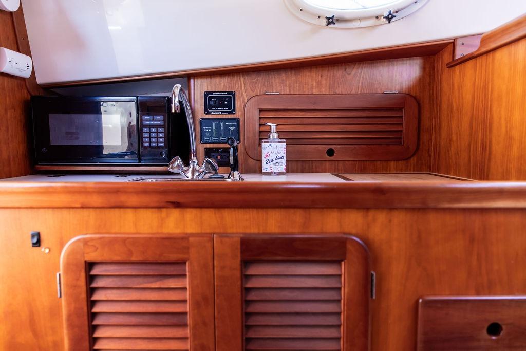 Hinckley Picnic Boat 36 Classic 2000 interior with wooden cabinetry, microwave, and sink.