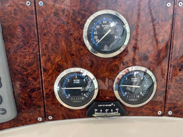 Dashboard of 2005 Formula 400 SS with speedometer and RPM gauges on wood panel.