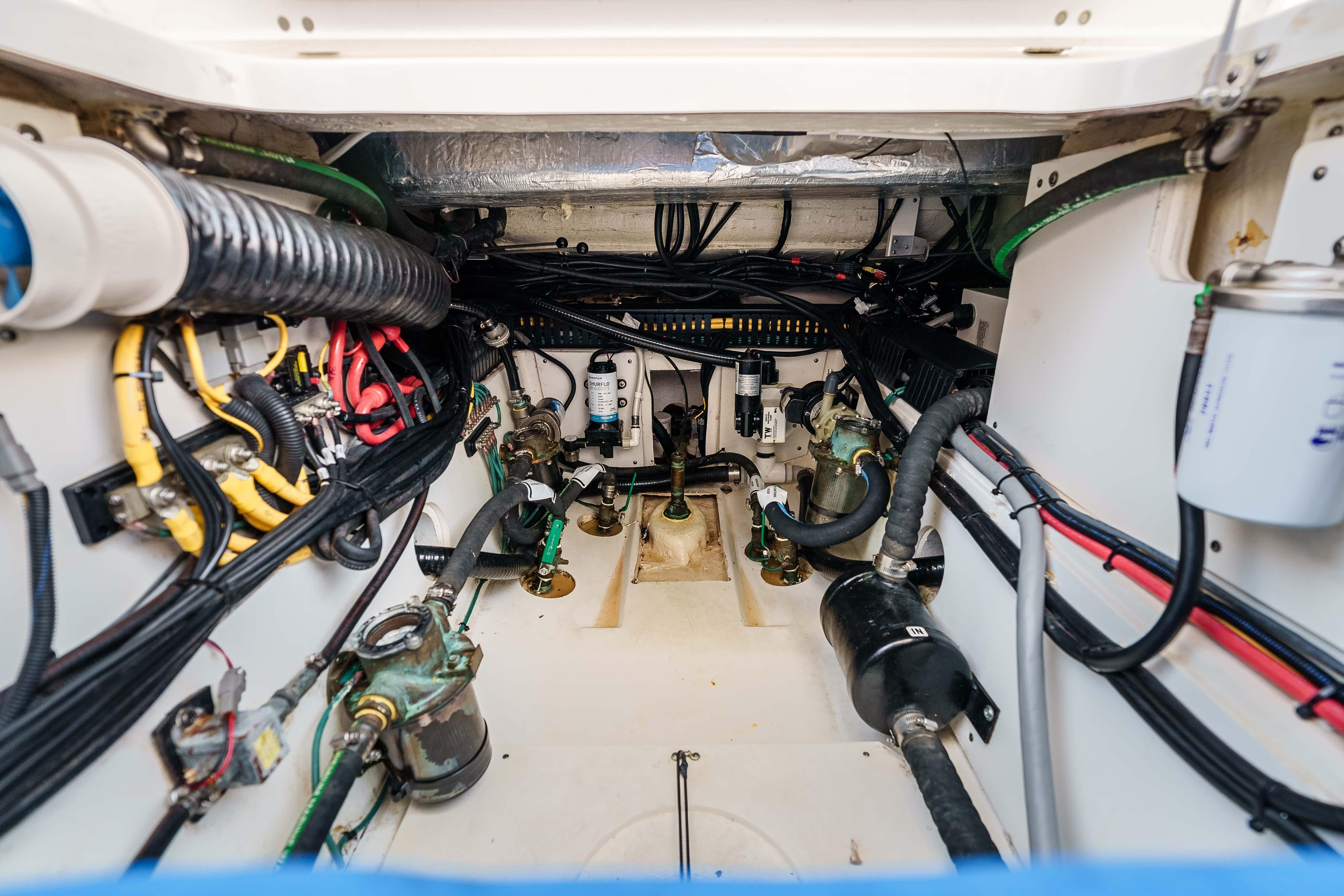 Engine compartment of 2022 Pursuit OS 385 Offshore boat, showcasing wiring and mechanical components.