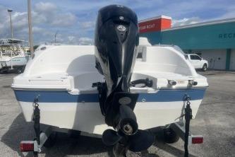 2022 Hurricane SunDeck 192 OB boat with outboard motor, parked outdoors.
