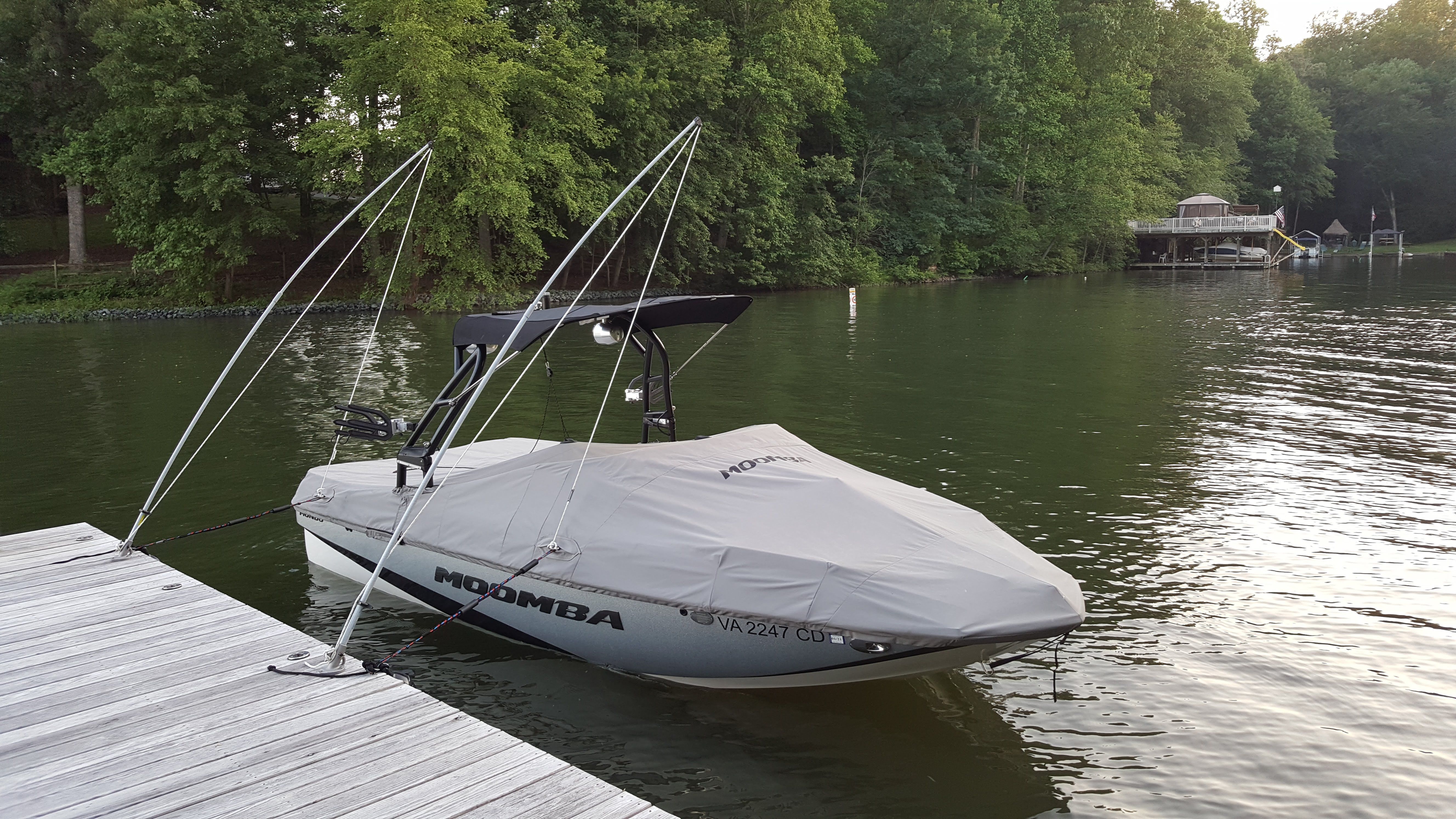 A 2016 Moomba Mondo boat docked at a wooden pier on a calm lake.