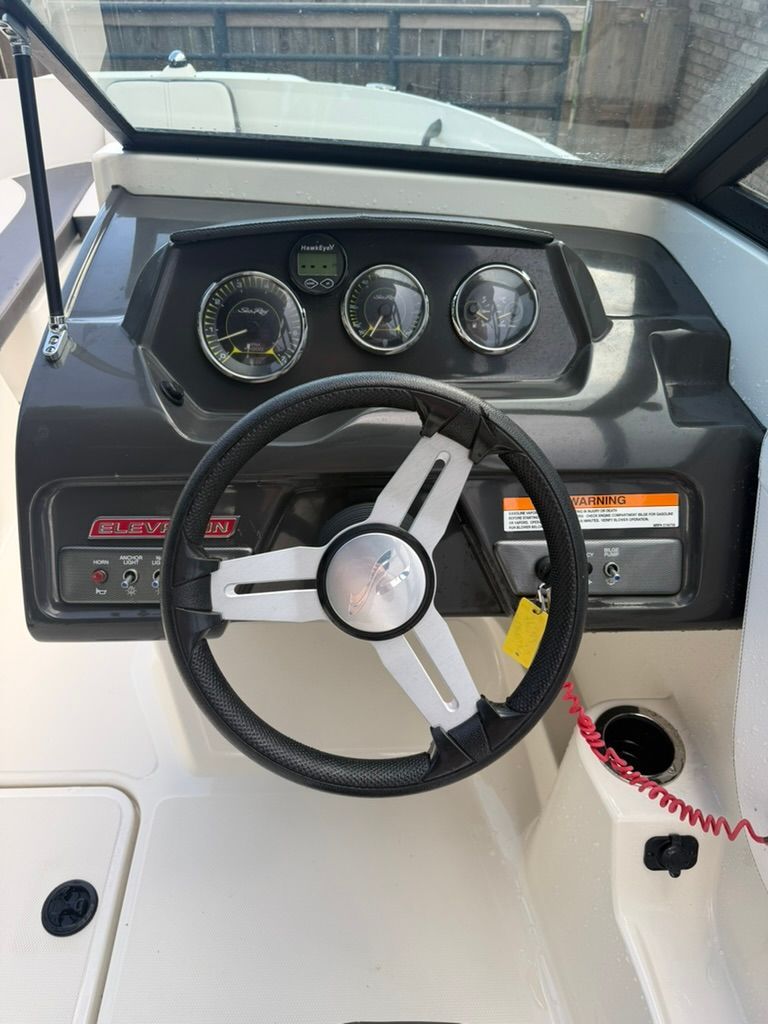 Steering wheel and dashboard of a Sea Ray SPX 210 Outboard boat.
