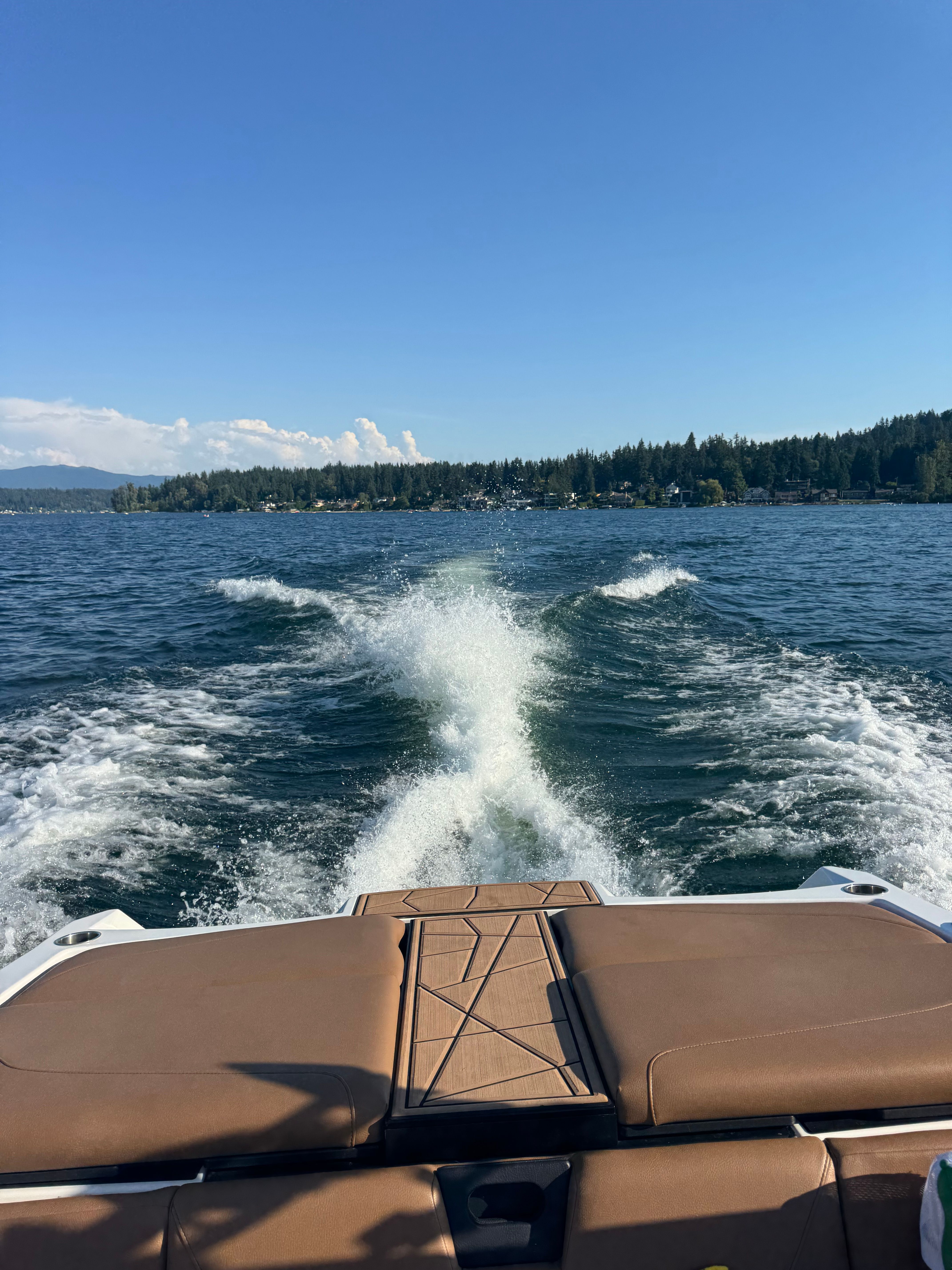 A 2022 ATX Surf Boat 22 Type-S on a lake, leaving a wake behind.
