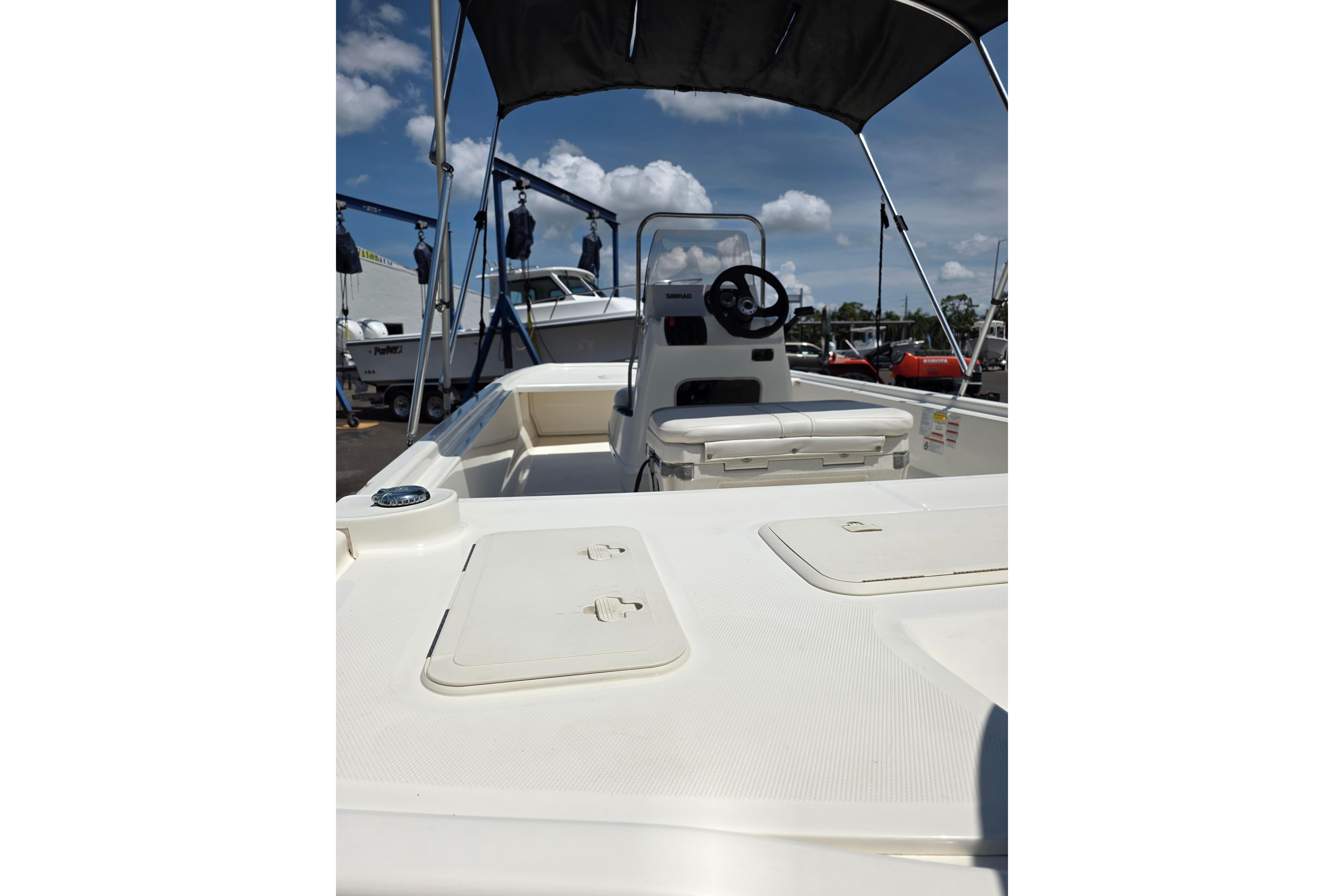 2018 Mako Pro Skiff 19 CC boat interior with steering console and seating under canopy.