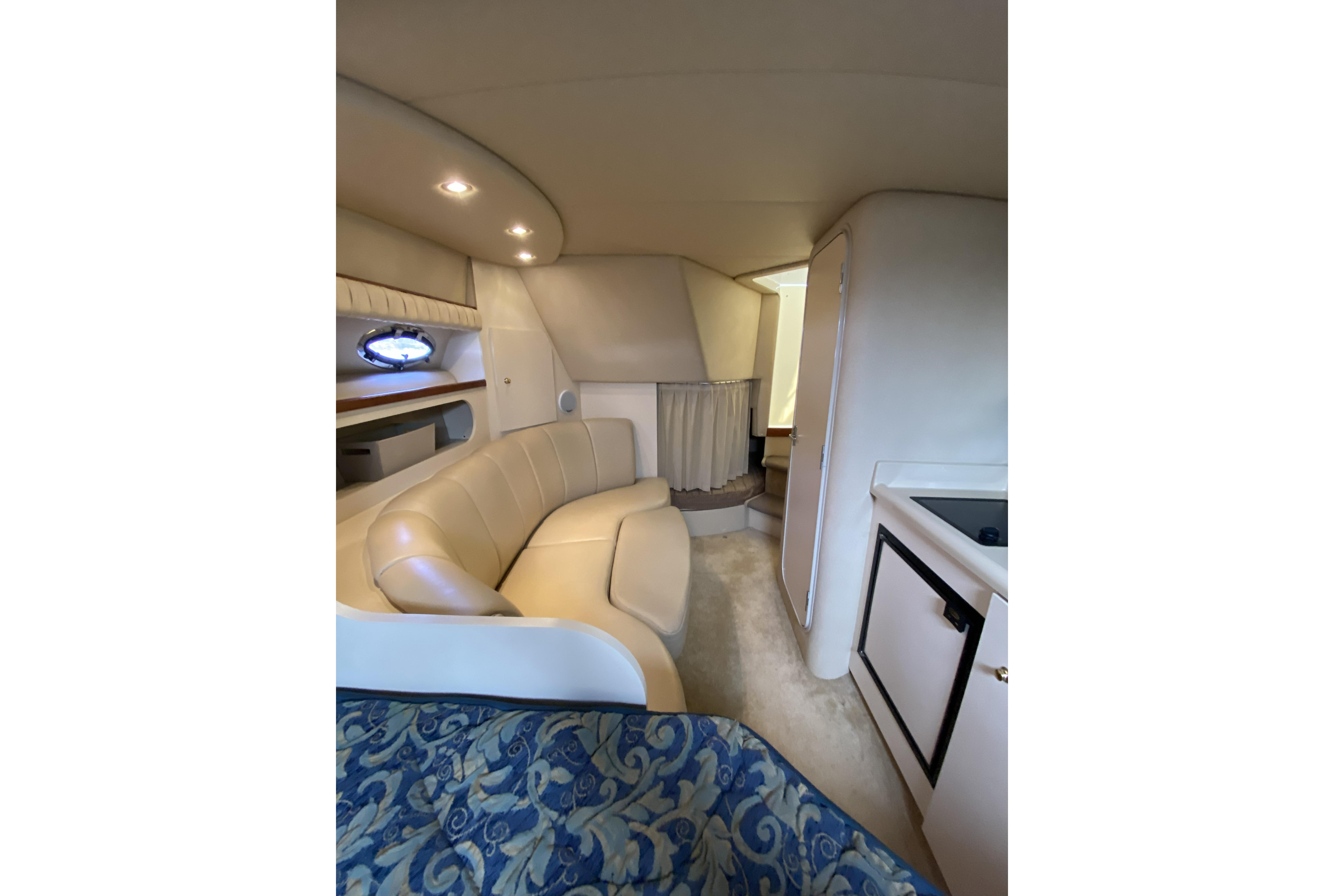 Interior of 2003 Cruisers Yachts 2870 Express, featuring a cozy seating area and compact kitchen.