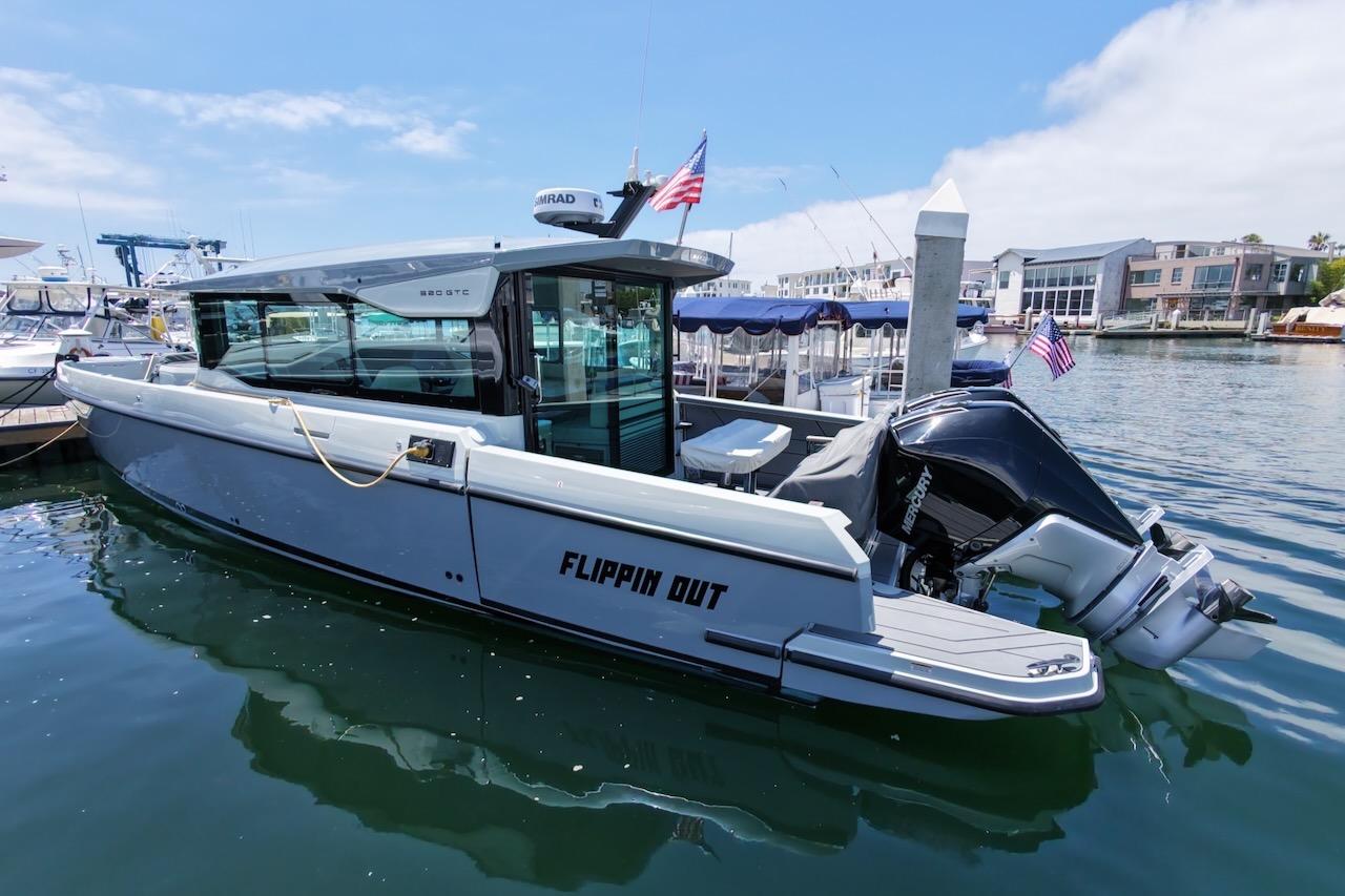 2024 Saxdor 320 GTC boat docked in marina, featuring sleek design and powerful outboard motor.